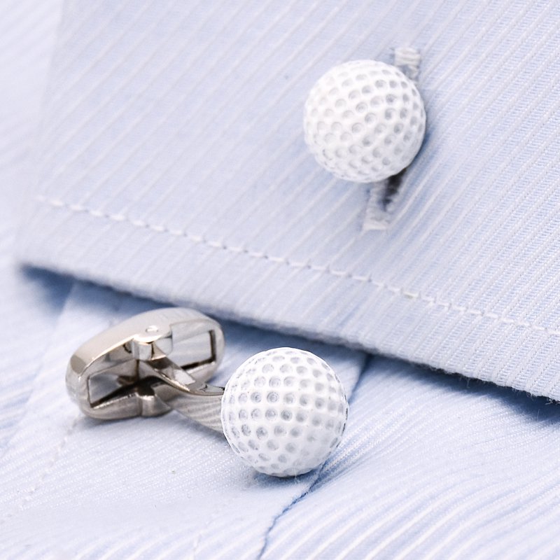 A pair of stainless steel golf ball cufflinks, hand-painted, displayed in a luxury presentation box, showcasing their unique design.