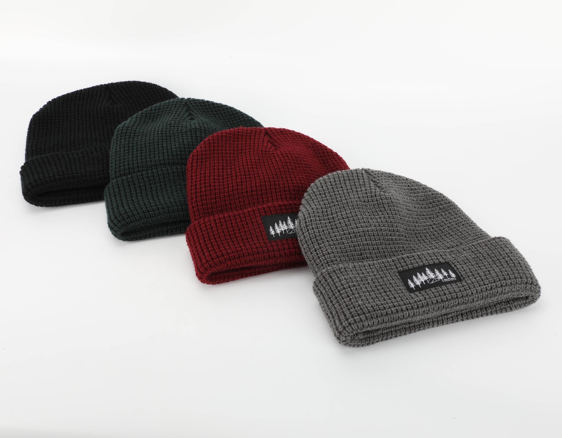 Burgundy Explorer Waffle Beanie displayed on a wooden surface, showcasing its thick knitted texture and stylish design.