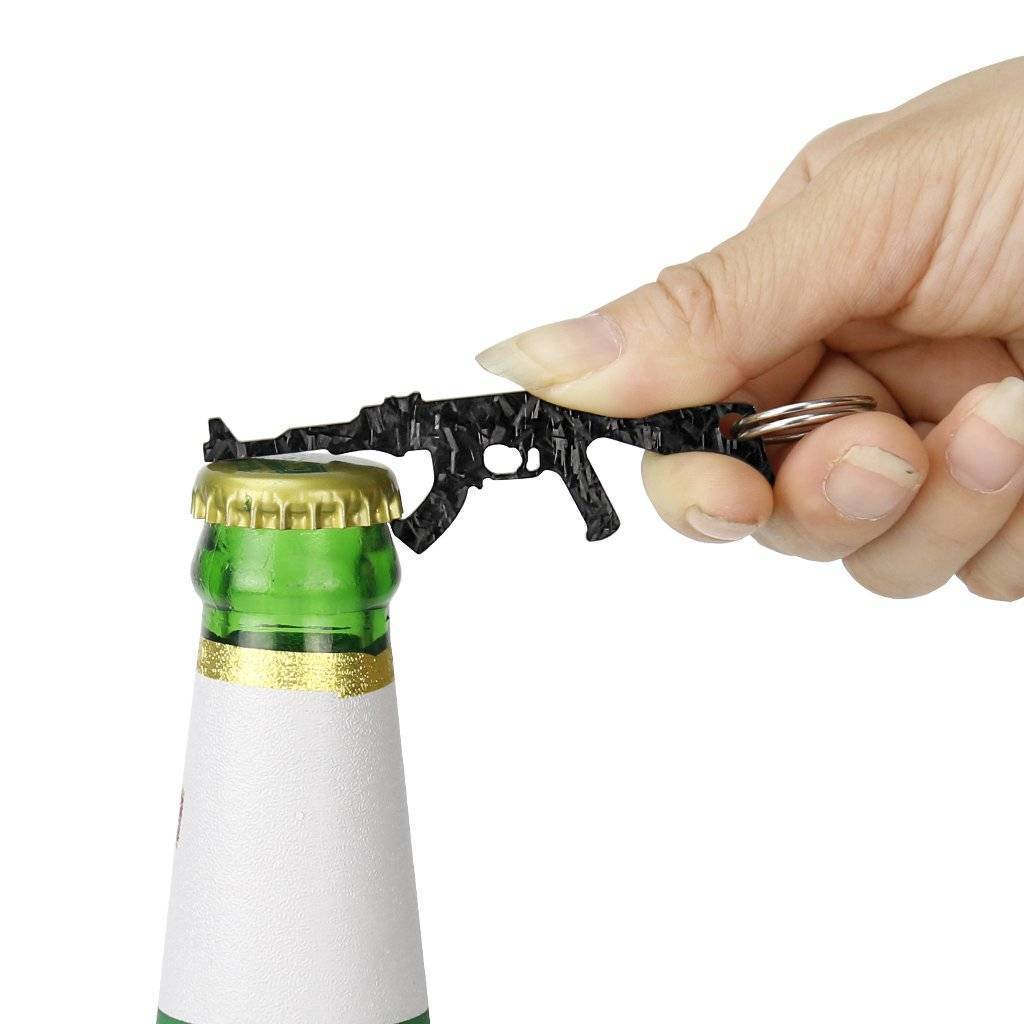 Forged carbon fiber keychain shaped like an AK-47, featuring a bottle opener and key ring, showcasing its sleek and durable design.