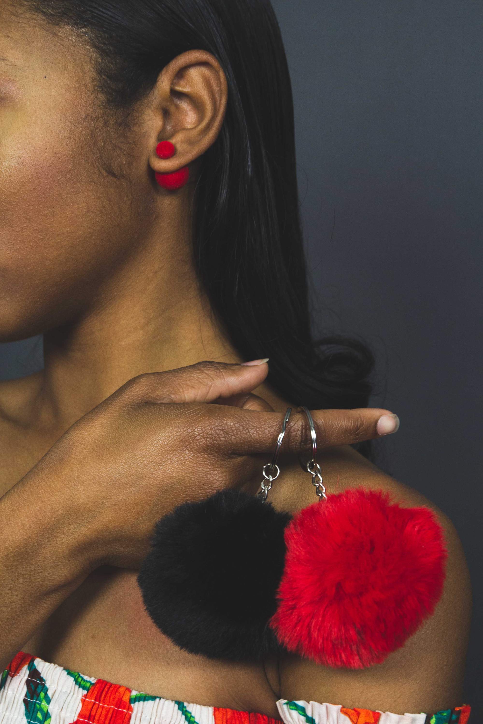 A colorful assortment of Puffs Keychains featuring fuzzy ball designs in purple, pink, white, black, red, and blue, showcasing their vibrant colors and textures.