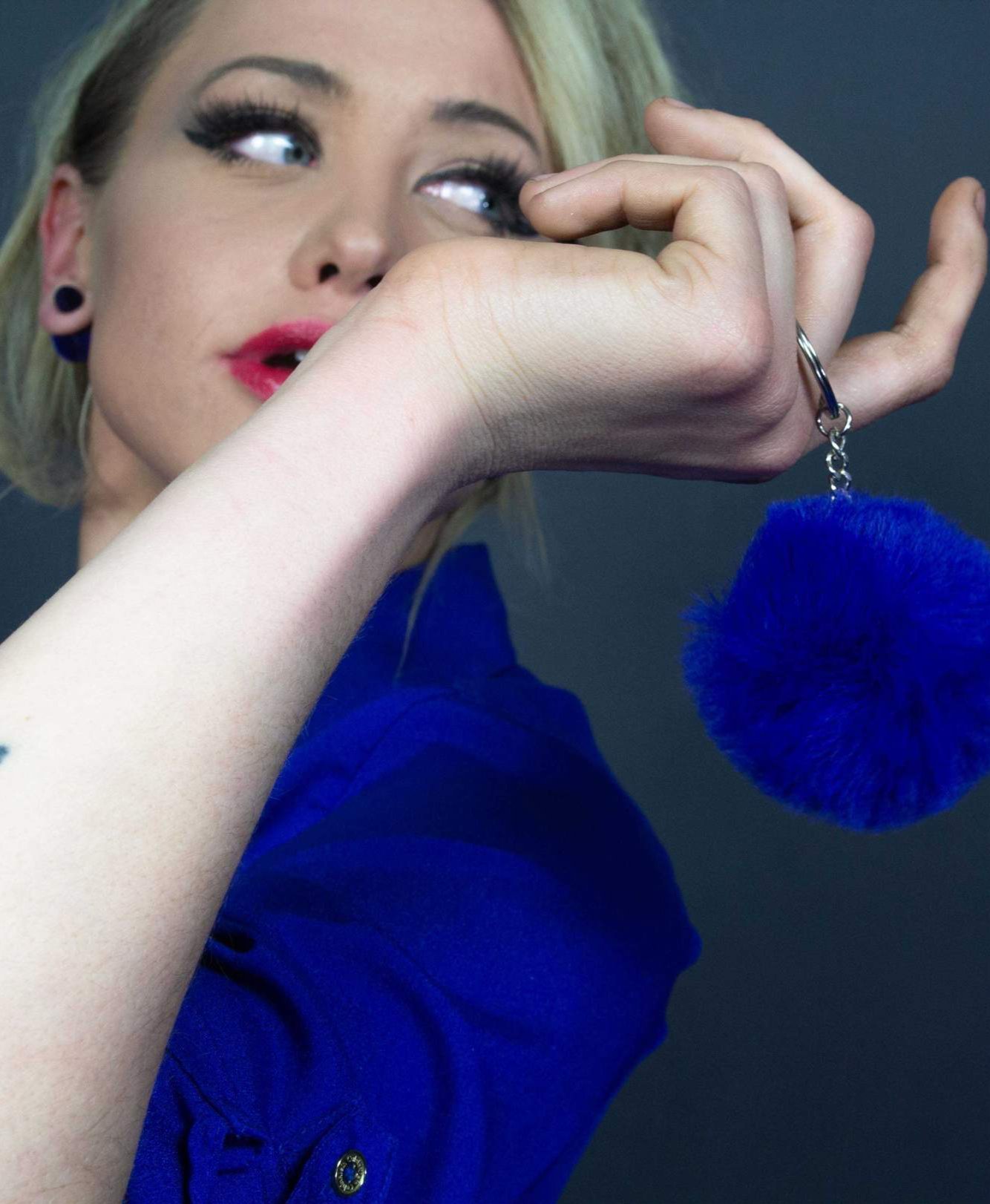 A colorful assortment of Puffs Keychains featuring fuzzy ball designs in purple, pink, white, black, red, and blue, showcasing their vibrant colors and textures.