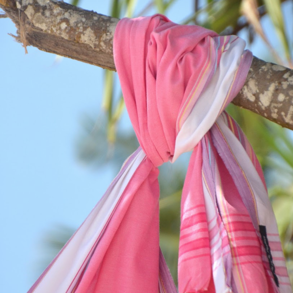 A vibrant peach African kikoi sarong, showcasing traditional hand-woven patterns, perfect for wraps and shawls.