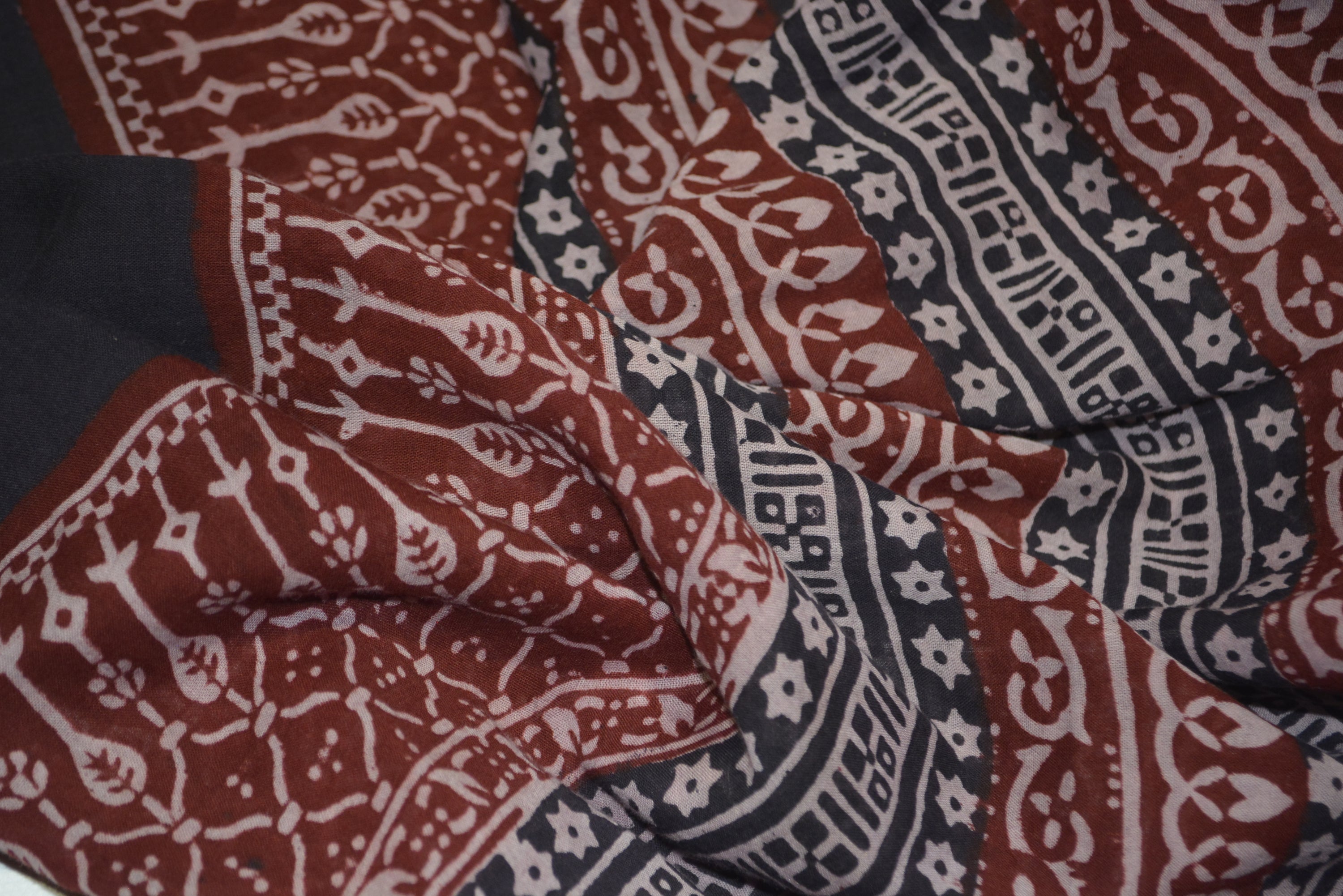 Red and black paisley design hand block printed cotton fabric showcasing intricate floral patterns and vintage motifs.