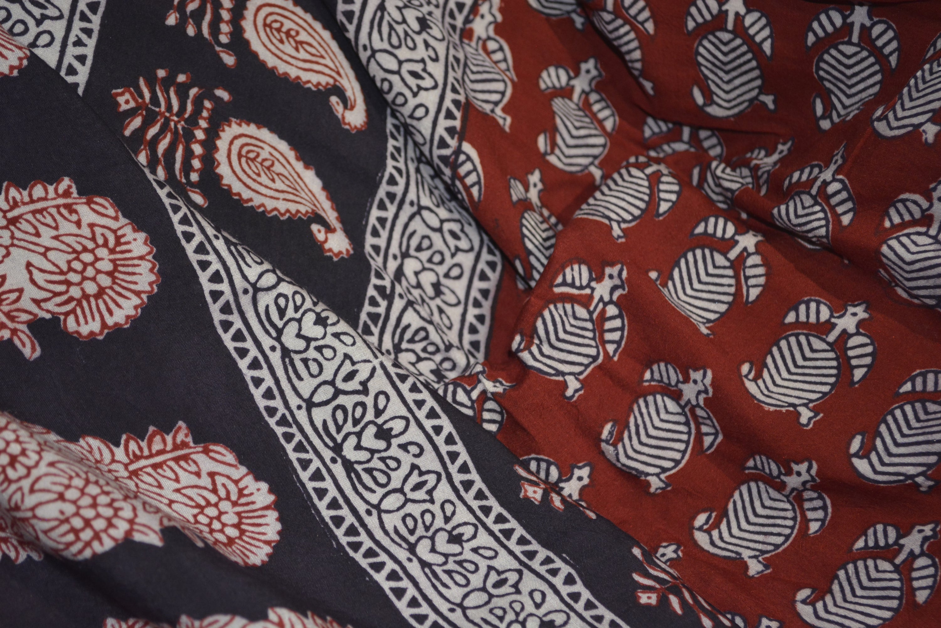 Red and black paisley design hand block printed cotton fabric showcasing intricate floral patterns and vintage motifs.