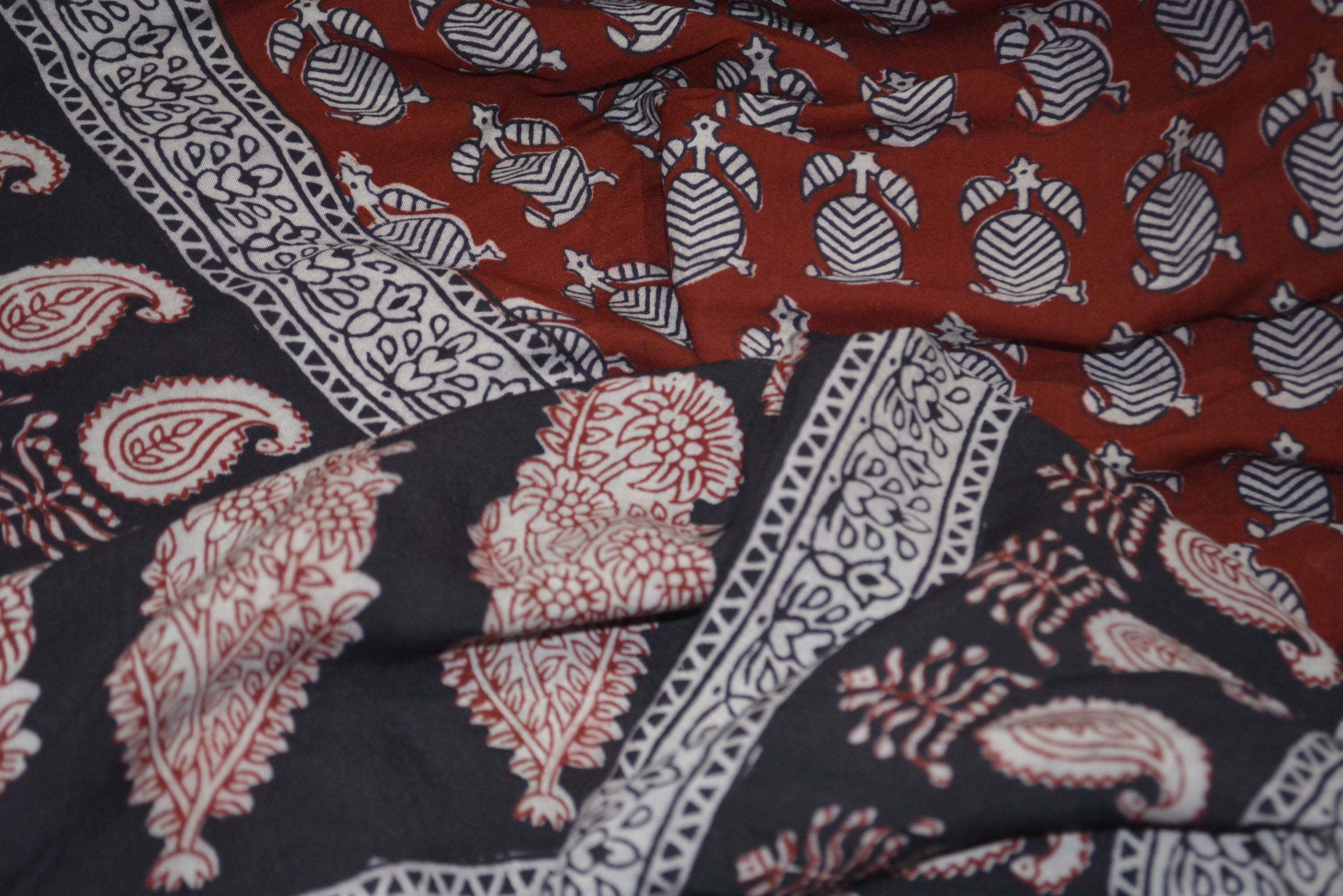 Red and black paisley design hand block printed cotton fabric showcasing intricate floral patterns and vintage motifs.