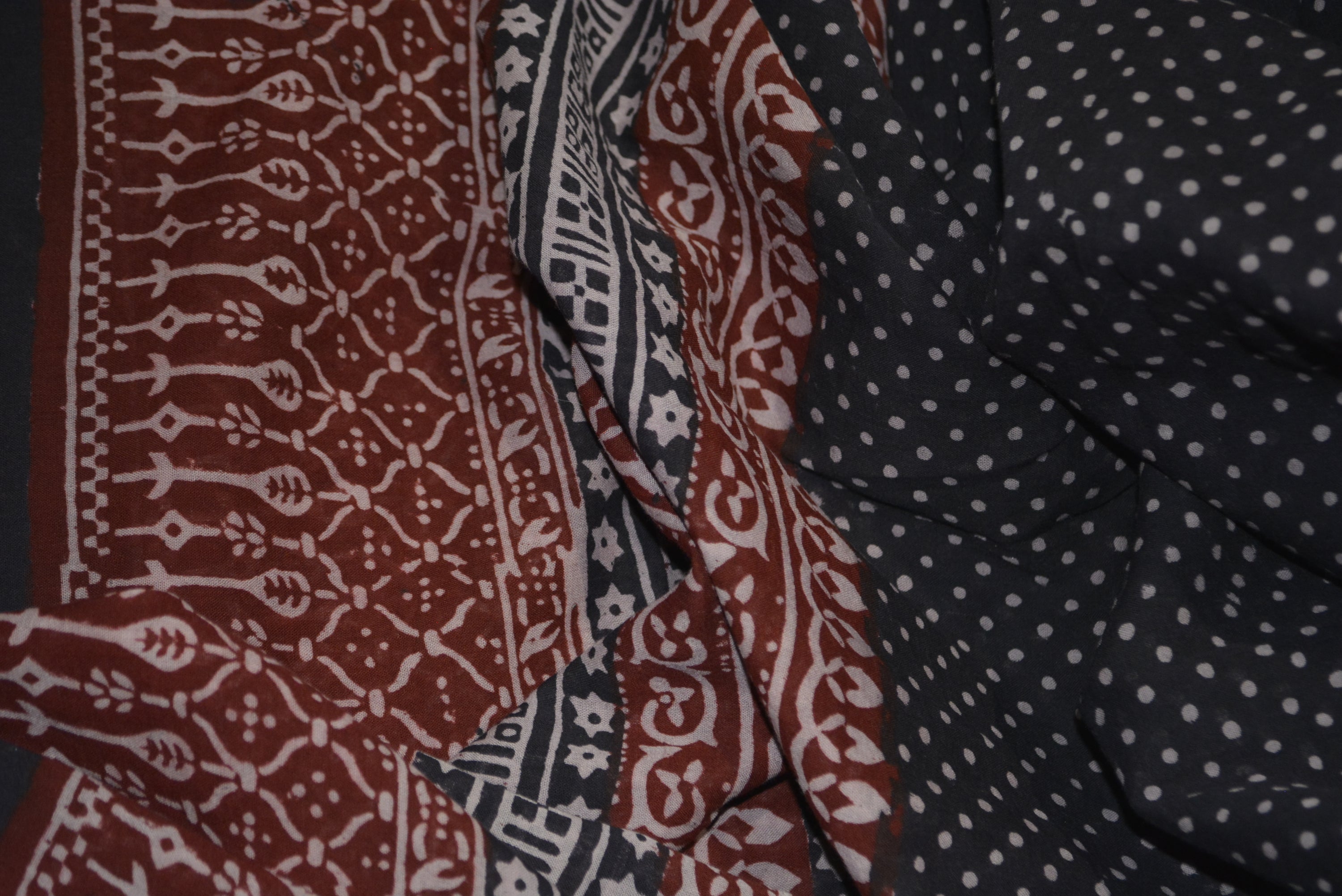 Red and black paisley design hand block printed cotton fabric showcasing intricate floral patterns and vintage motifs.