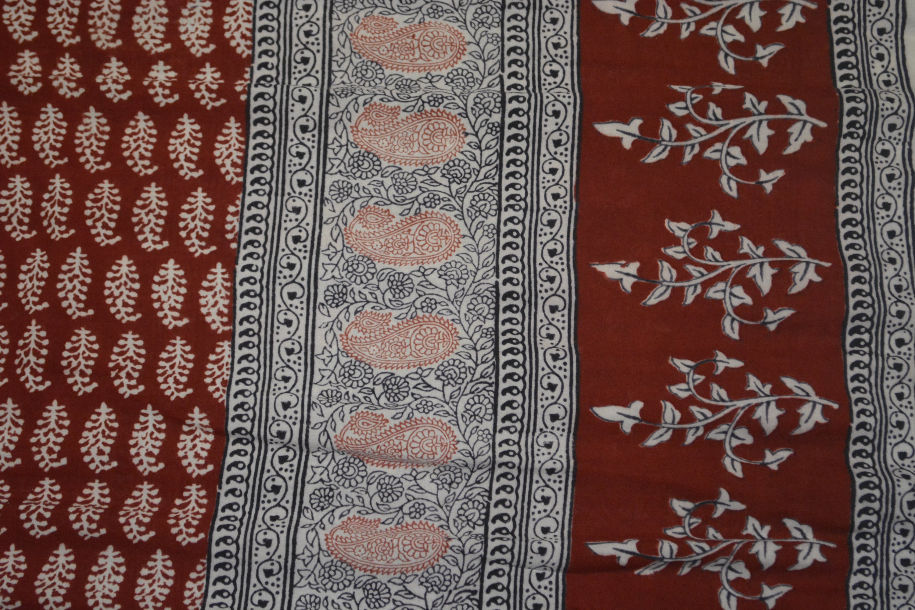 Red and black paisley design hand block printed cotton fabric showcasing intricate floral patterns and vintage motifs.