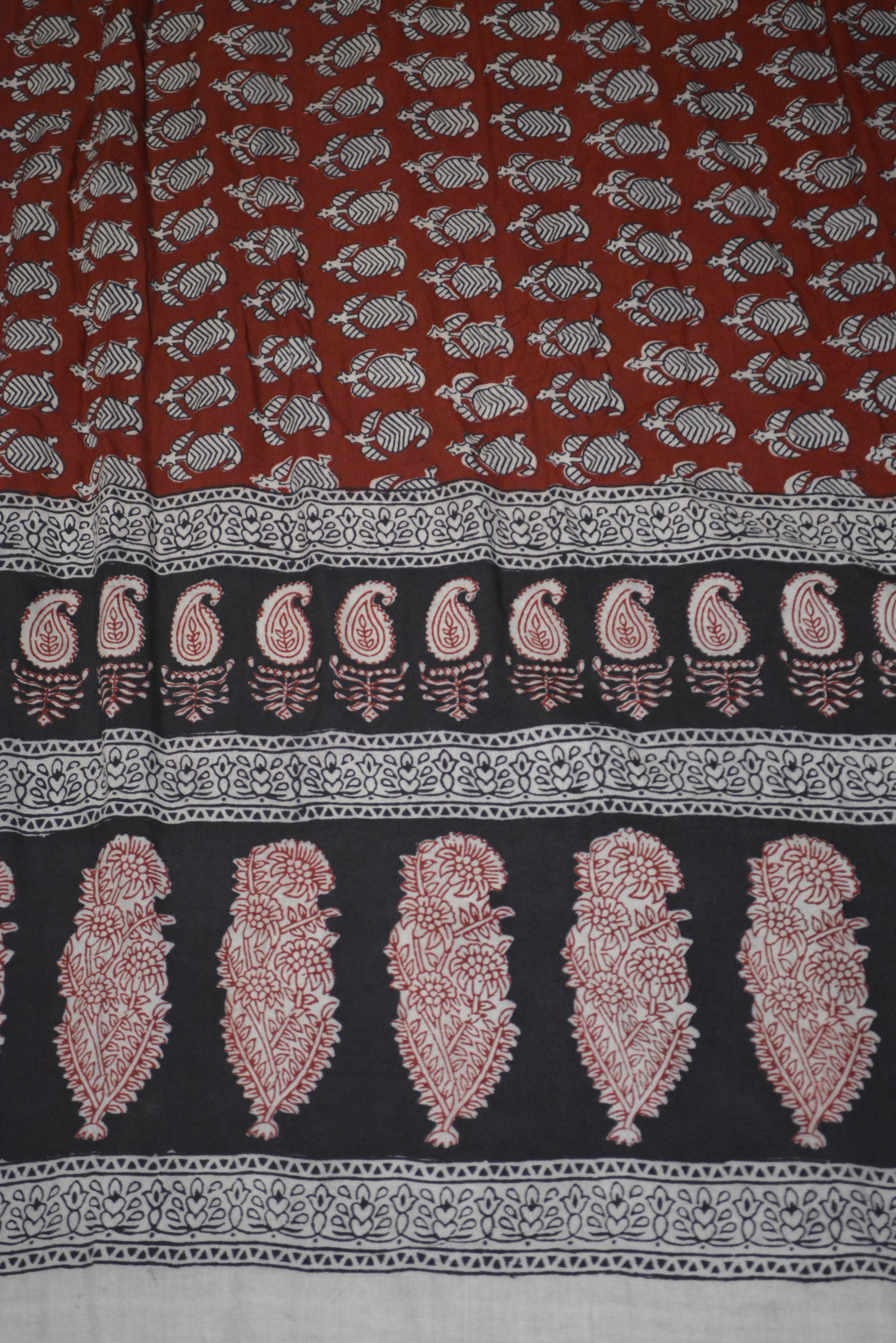 Red and black paisley design hand block printed cotton fabric showcasing intricate floral patterns and vintage motifs.