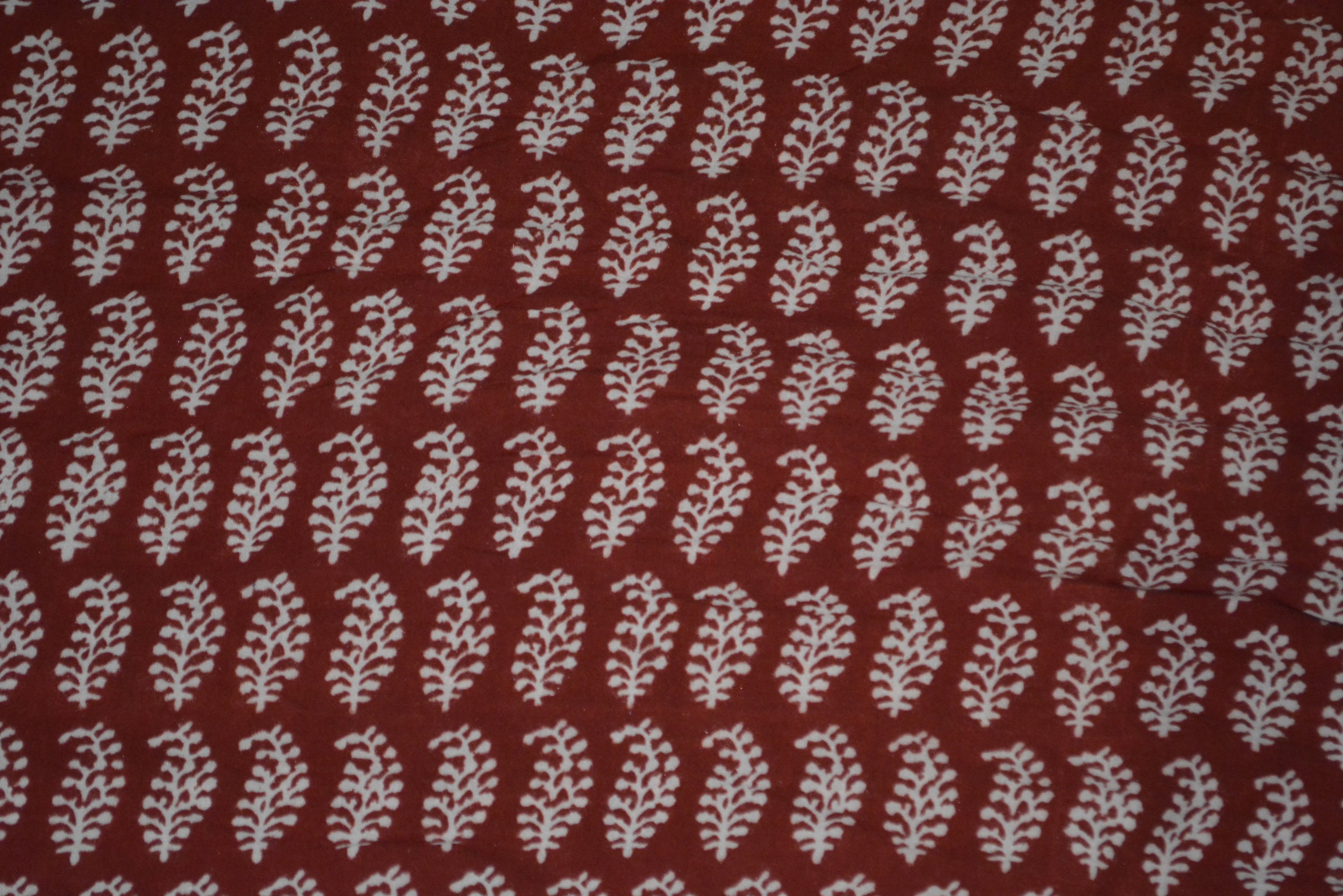 Red and black paisley design hand block printed cotton fabric showcasing intricate floral patterns and vintage motifs.