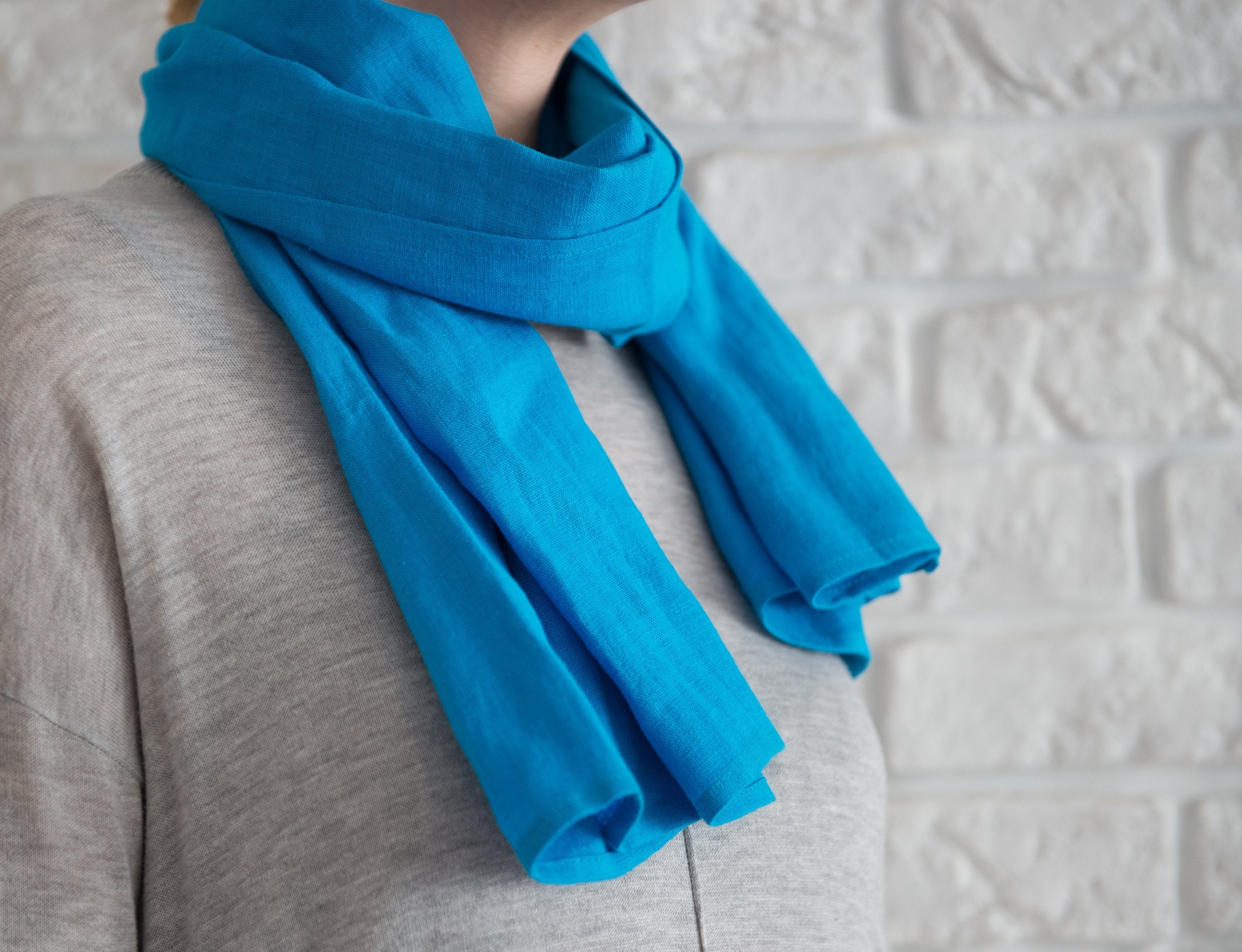 Sky Blue linen scarf made from 100% stonewashed linen, featuring a soft texture and available in two sizes with stylish hem or tassels.