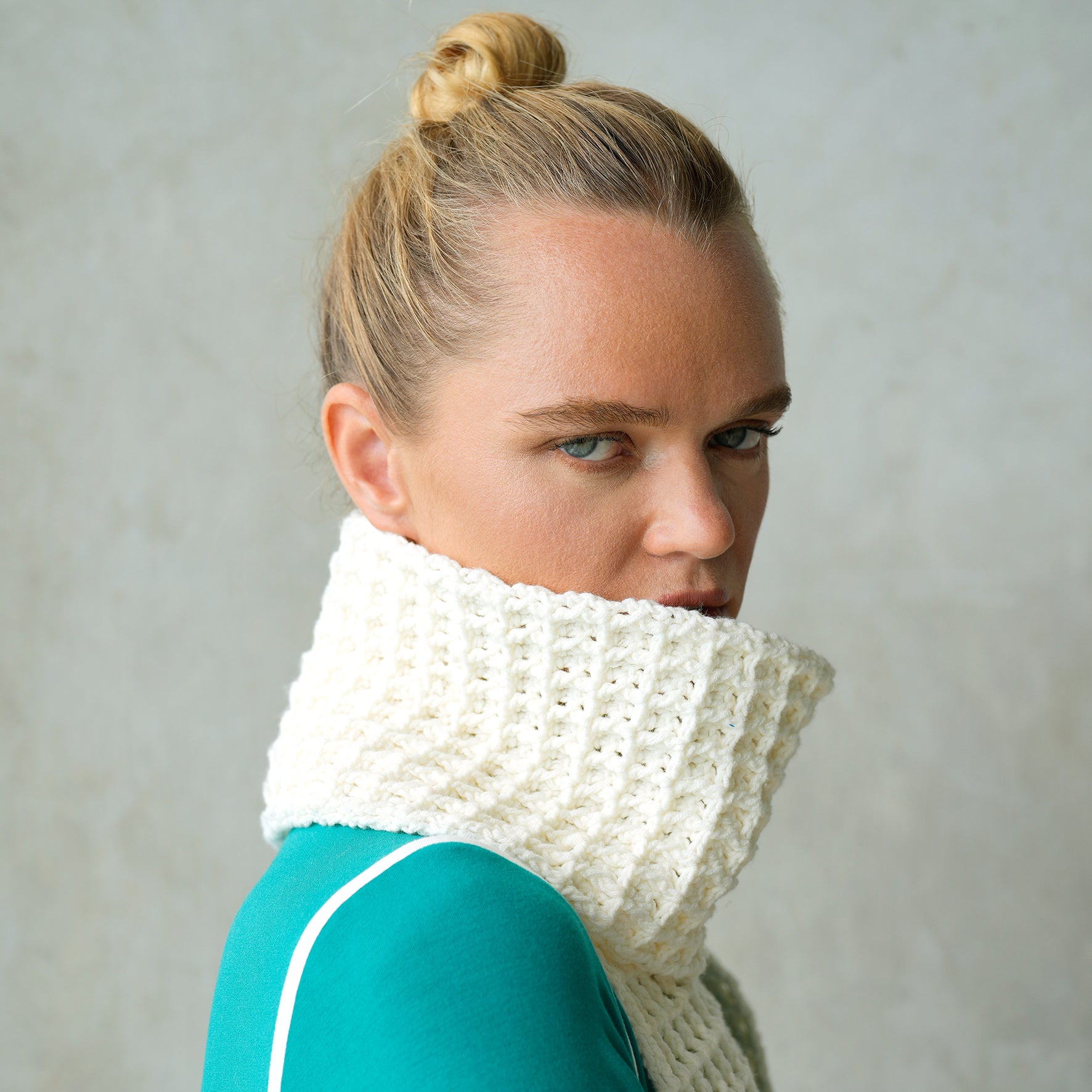 A cozy off-white crochet scarf featuring a waffle pattern, handmade from soft cotton yarn, draped elegantly on a neutral background.