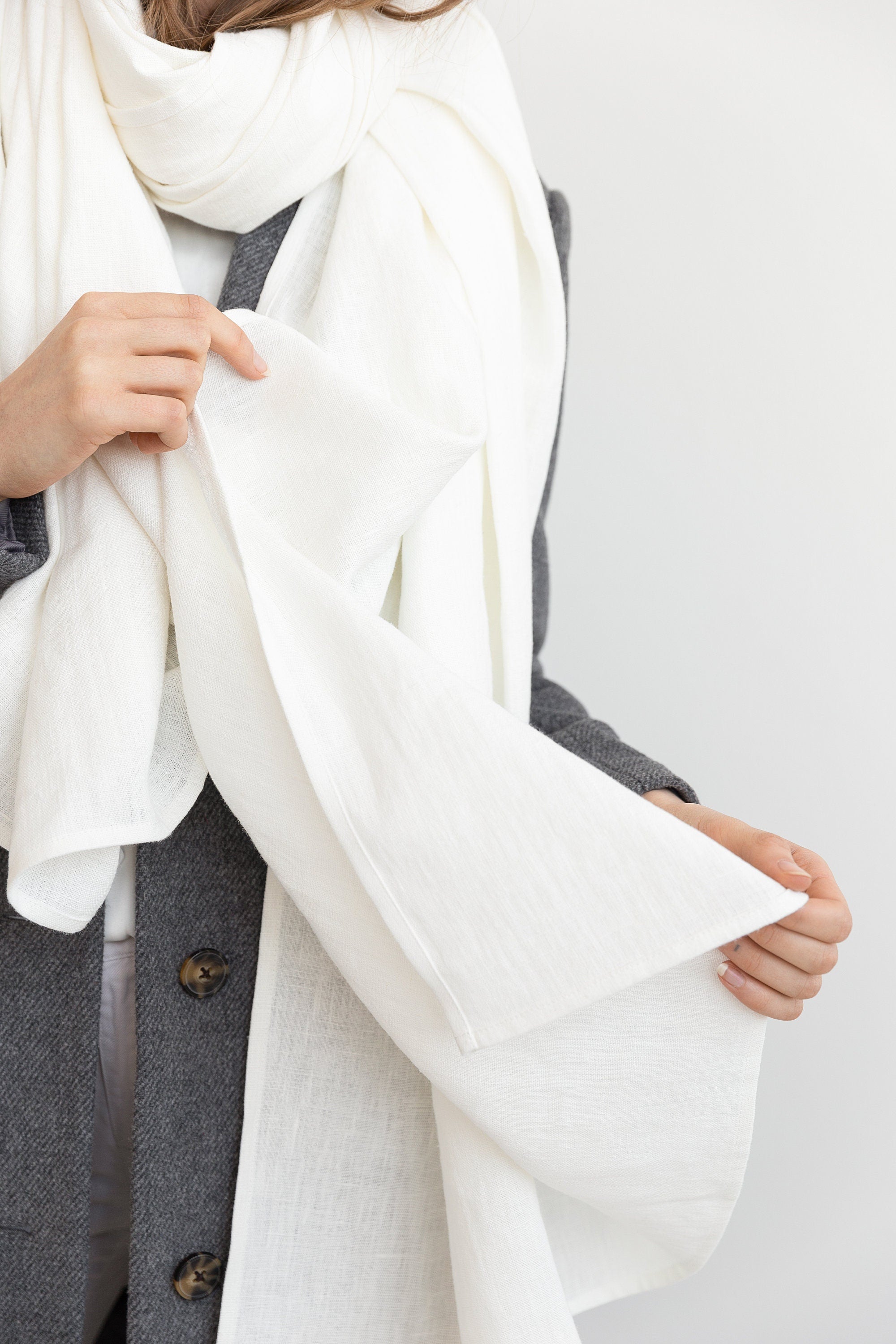 A stylish white linen scarf made from 100% stonewashed linen, showcasing its soft texture and elegant design.