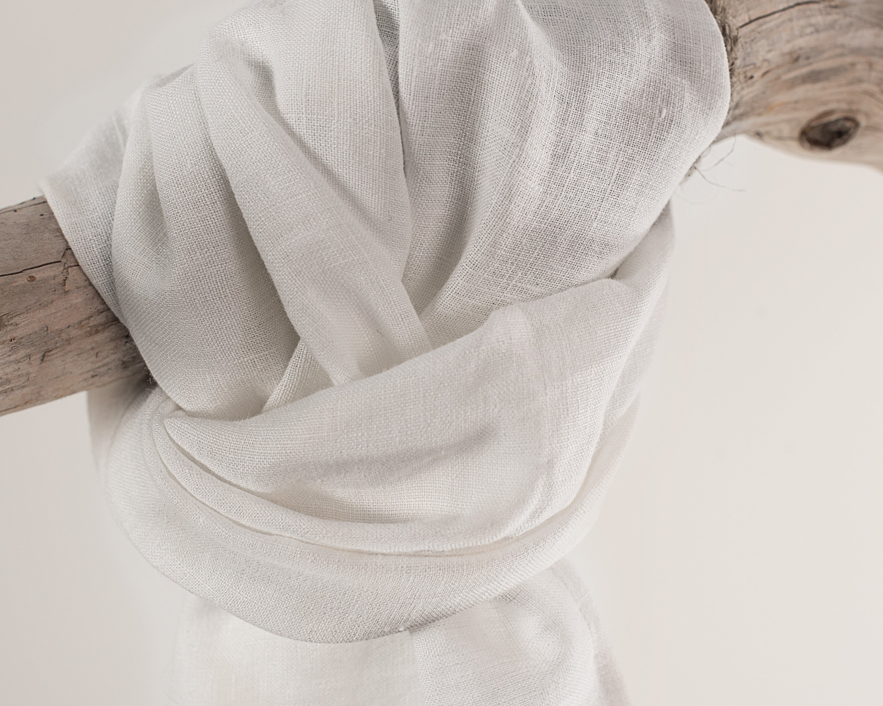 A stylish white linen scarf made from 100% stonewashed linen, showcasing its soft texture and elegant design.