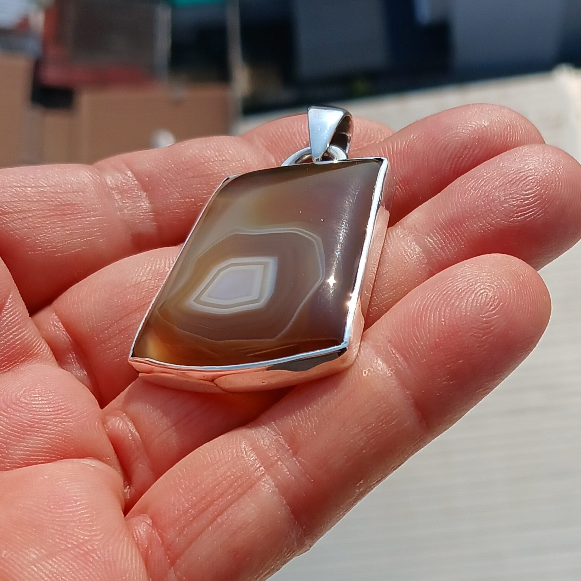 A stunning honey-colored Agate stone set in a beautifully crafted sterling silver pendant, showcasing intricate artwork.