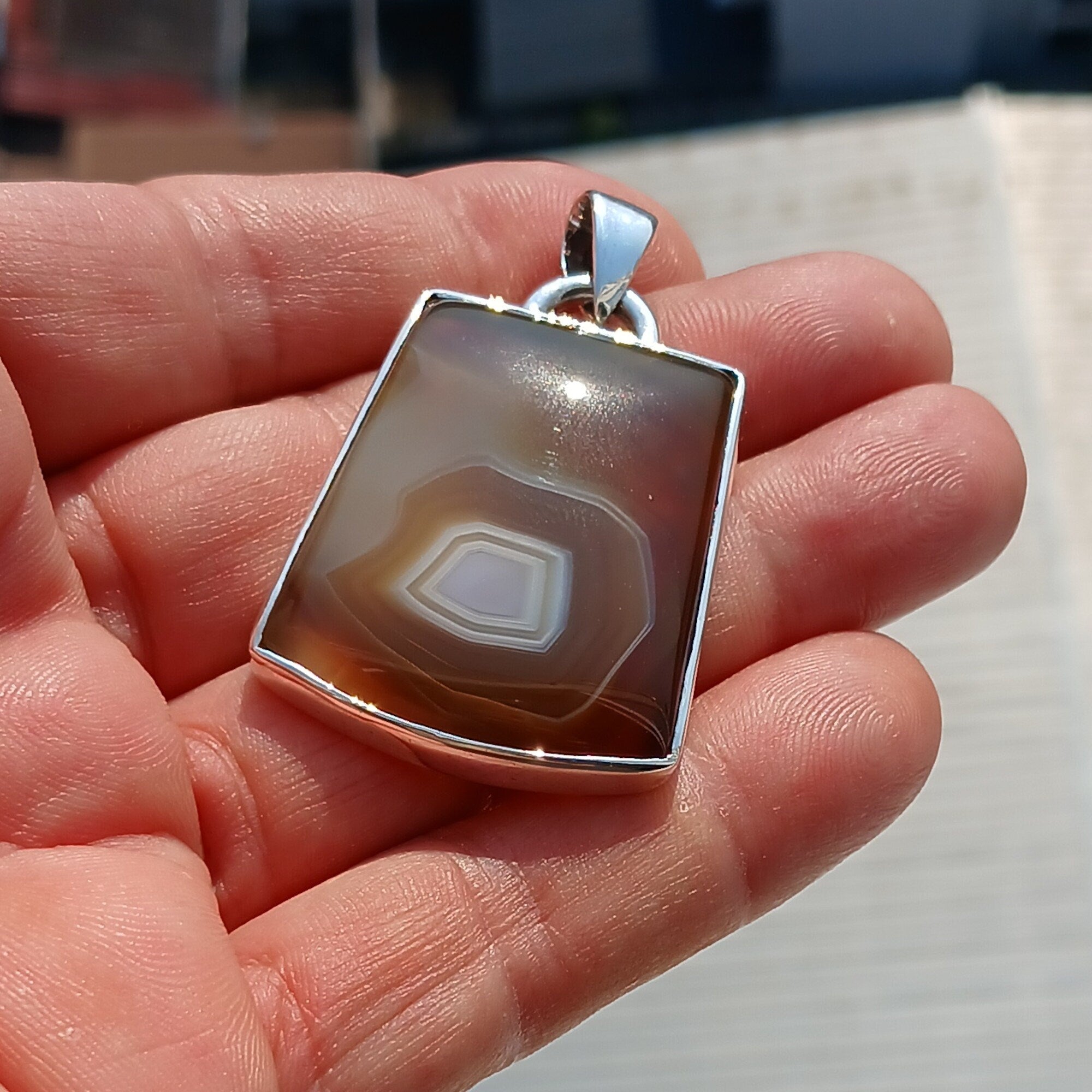 A stunning honey-colored Agate stone set in a beautifully crafted sterling silver pendant, showcasing intricate artwork.