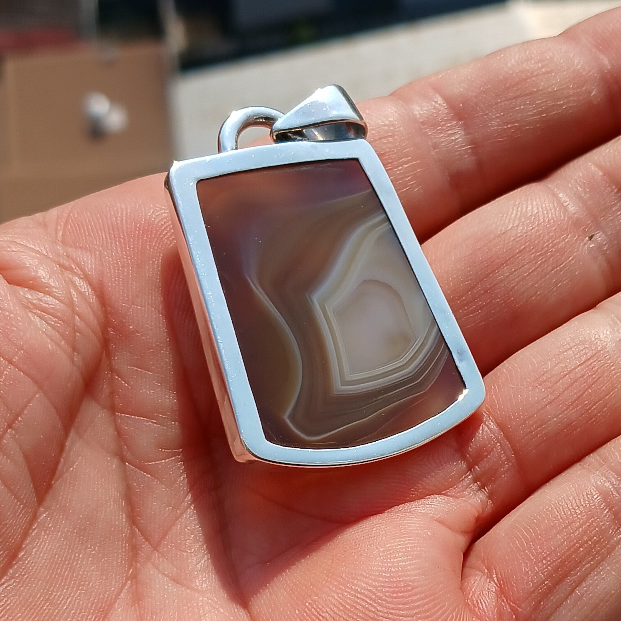 A stunning honey-colored Agate stone set in a beautifully crafted sterling silver pendant, showcasing intricate artwork.