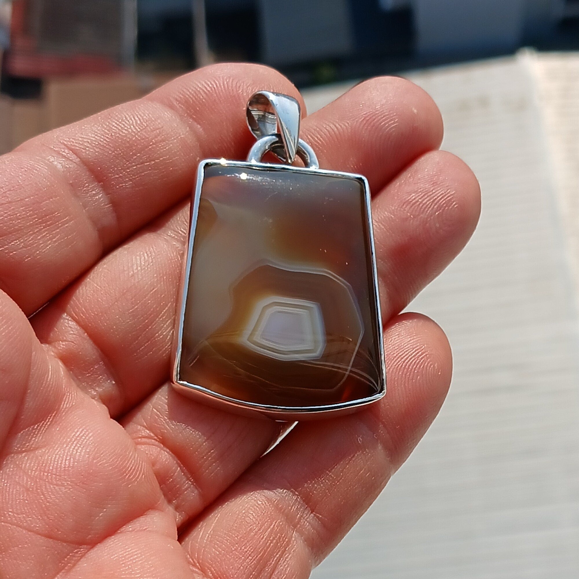 A stunning honey-colored Agate stone set in a beautifully crafted sterling silver pendant, showcasing intricate artwork.