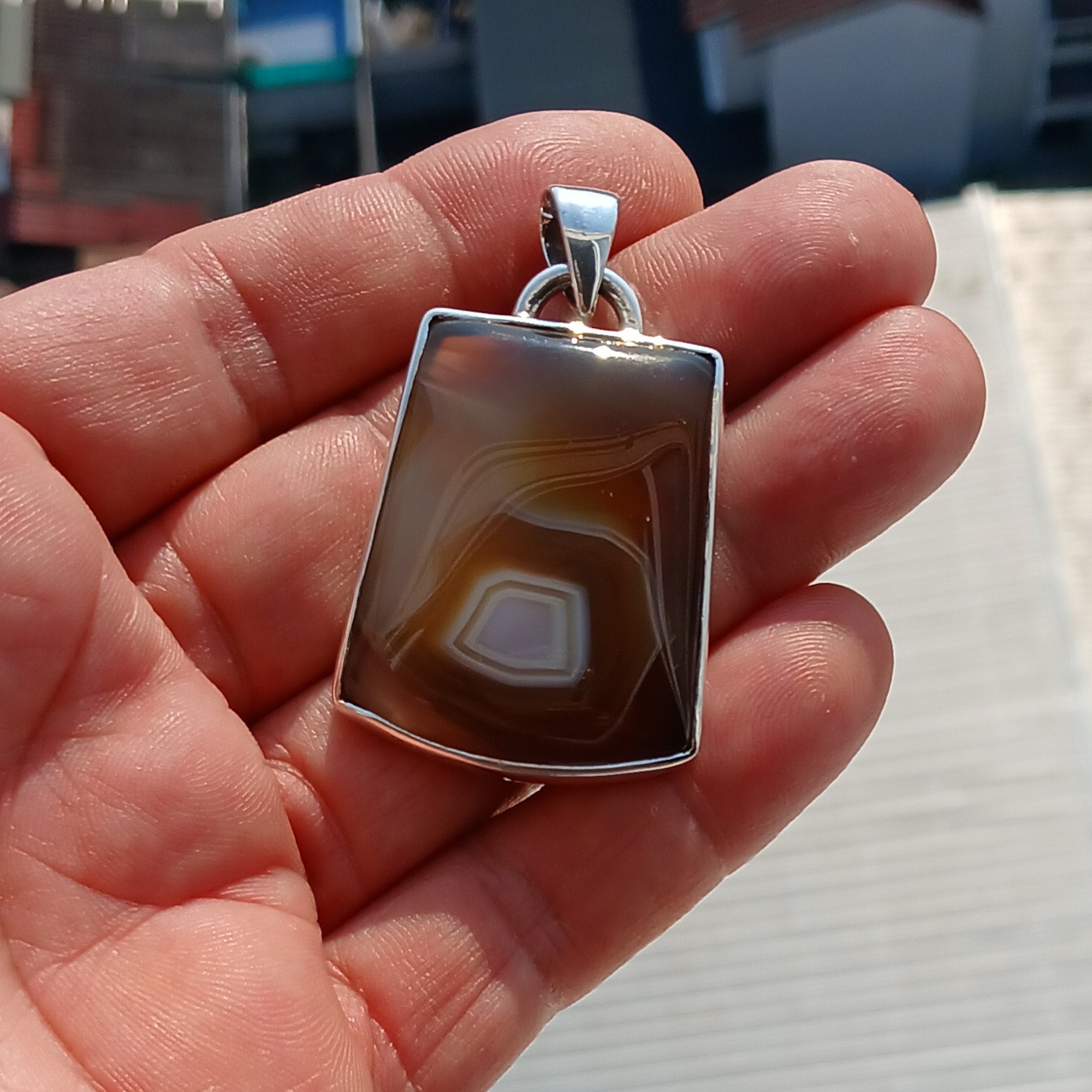 A stunning honey-colored Agate stone set in a beautifully crafted sterling silver pendant, showcasing intricate artwork.