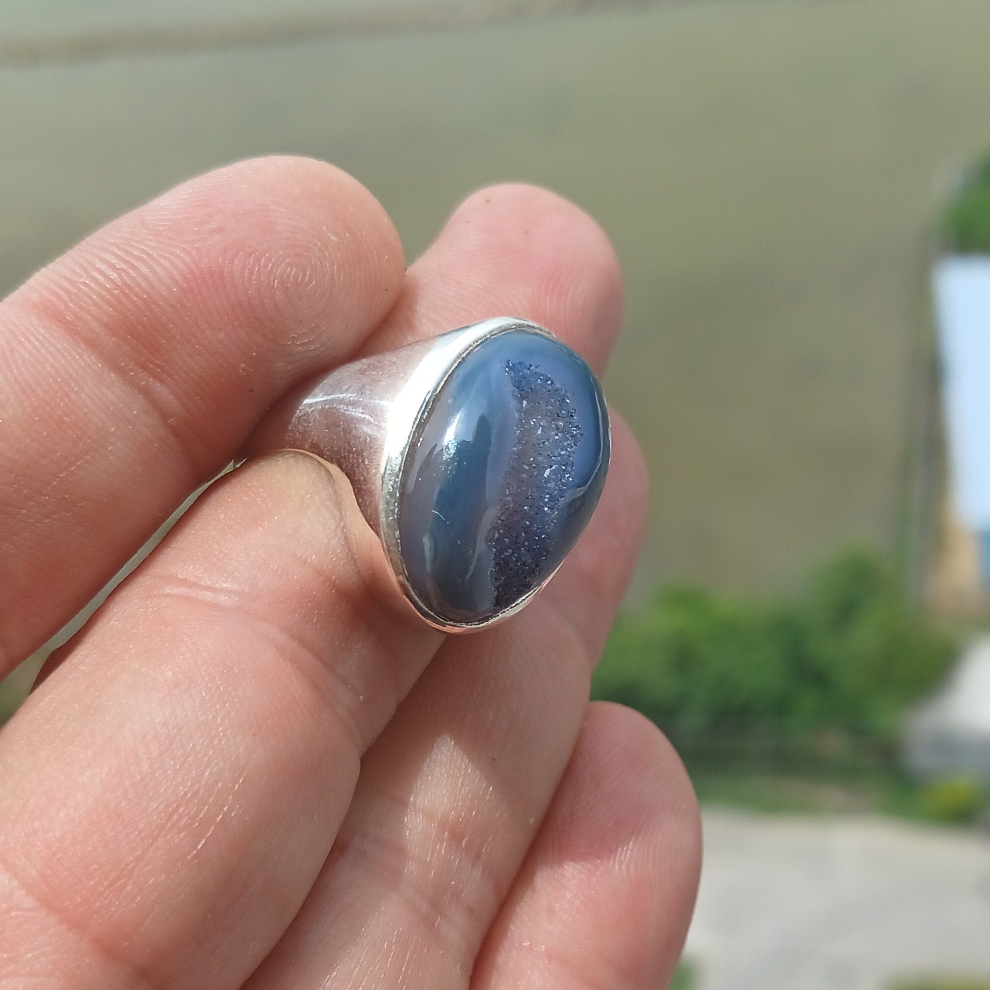 A stunning oval-shaped blue Agate cabochon ring set in polished sterling silver, showcasing intricate craftsmanship.