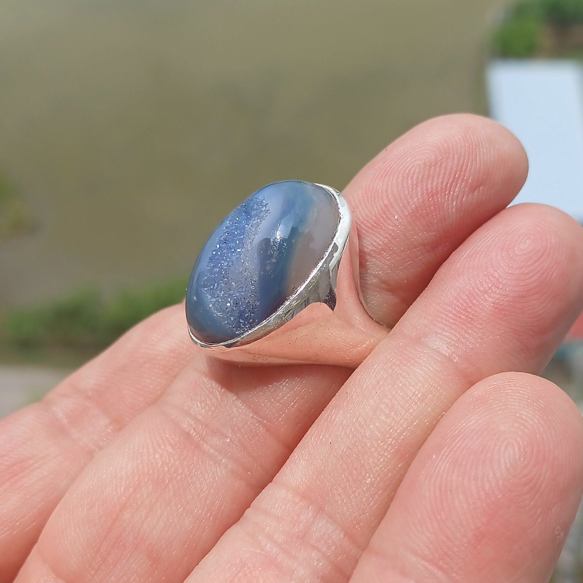 A stunning oval-shaped blue Agate cabochon ring set in polished sterling silver, showcasing intricate craftsmanship.