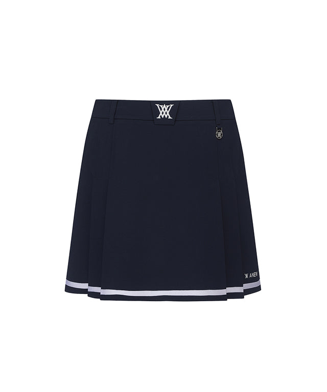 Navy A-line skirt with two-tier pleats, featuring a D-ring logo and color point tape at the hem.