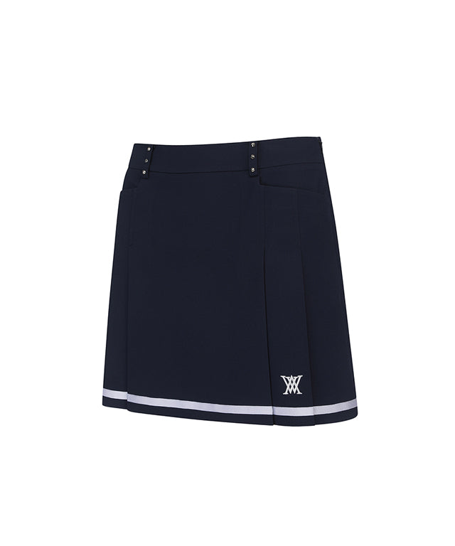 Navy A-line skirt with two-tier pleats, featuring a D-ring logo and color point tape at the hem.