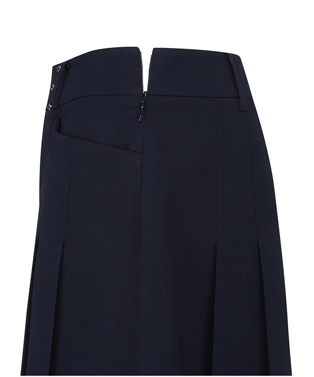 Navy A-line skirt with two-tier pleats, featuring a D-ring logo and color point tape at the hem.
