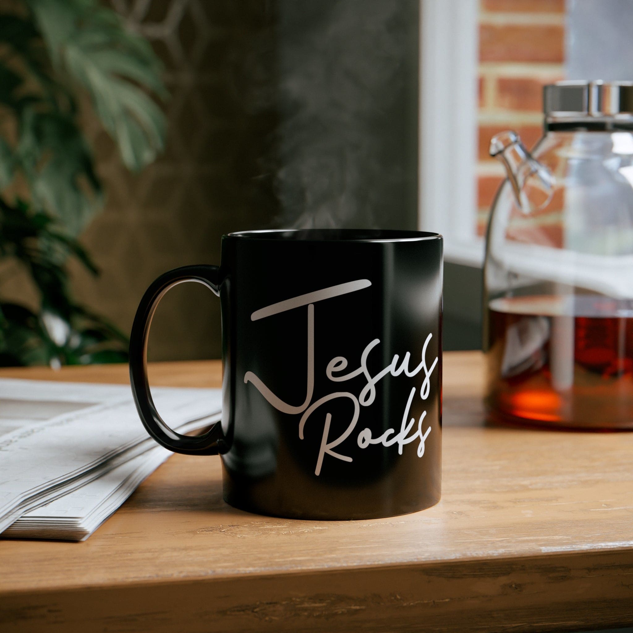 A sleek black ceramic mug with a glossy finish, featuring the inspirational text 'Jesus Rocks' in a modern font, perfect for coffee or tea.