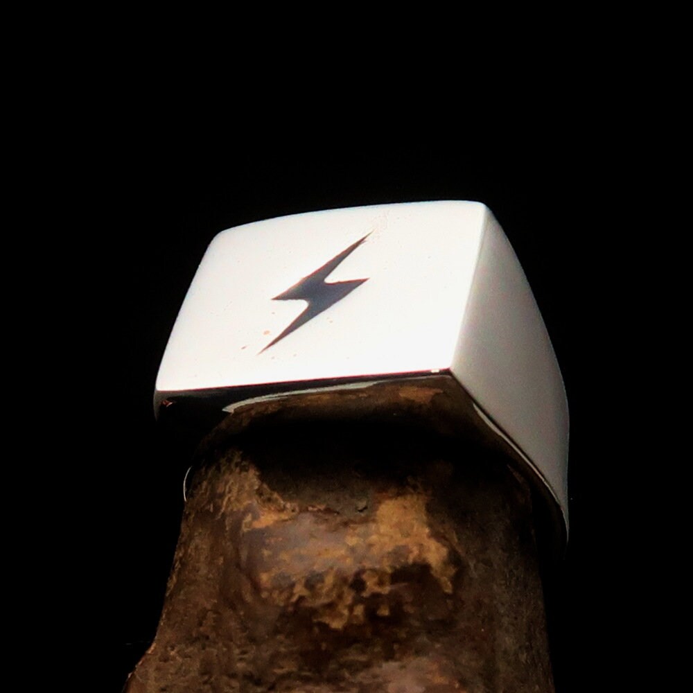 A sleek Black Lightning Ring featuring a square design and lightning bolt motif, crafted from polished sterling silver with black enamel inlay.