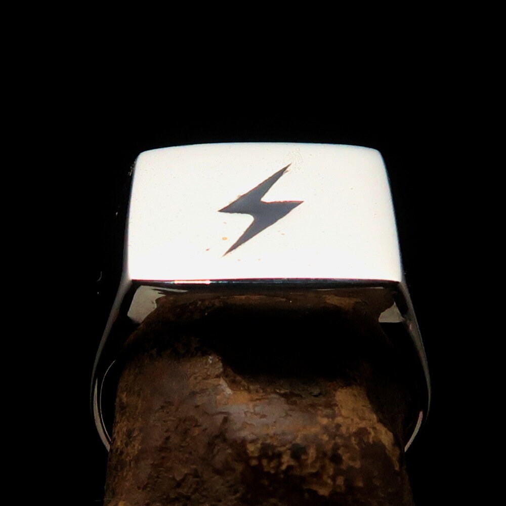 A sleek Black Lightning Ring featuring a square design and lightning bolt motif, crafted from polished sterling silver with black enamel inlay.