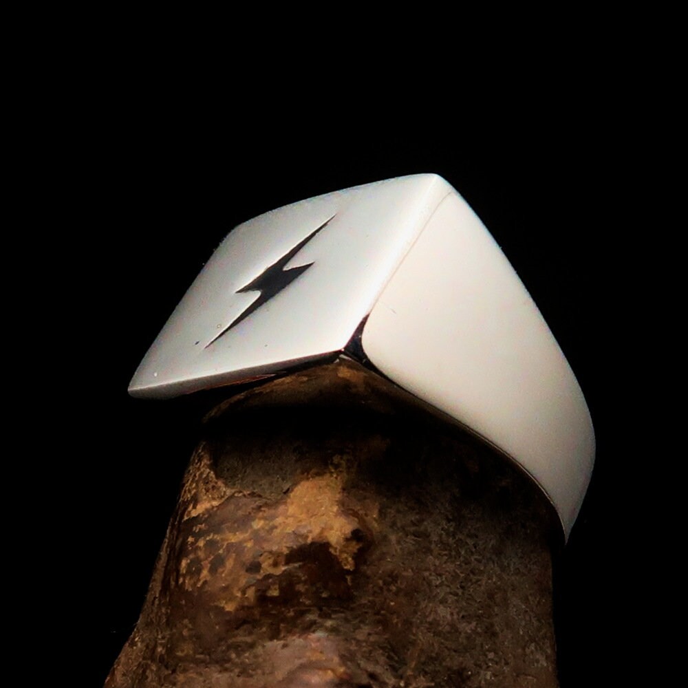 A sleek Black Lightning Ring featuring a square design and lightning bolt motif, crafted from polished sterling silver with black enamel inlay.