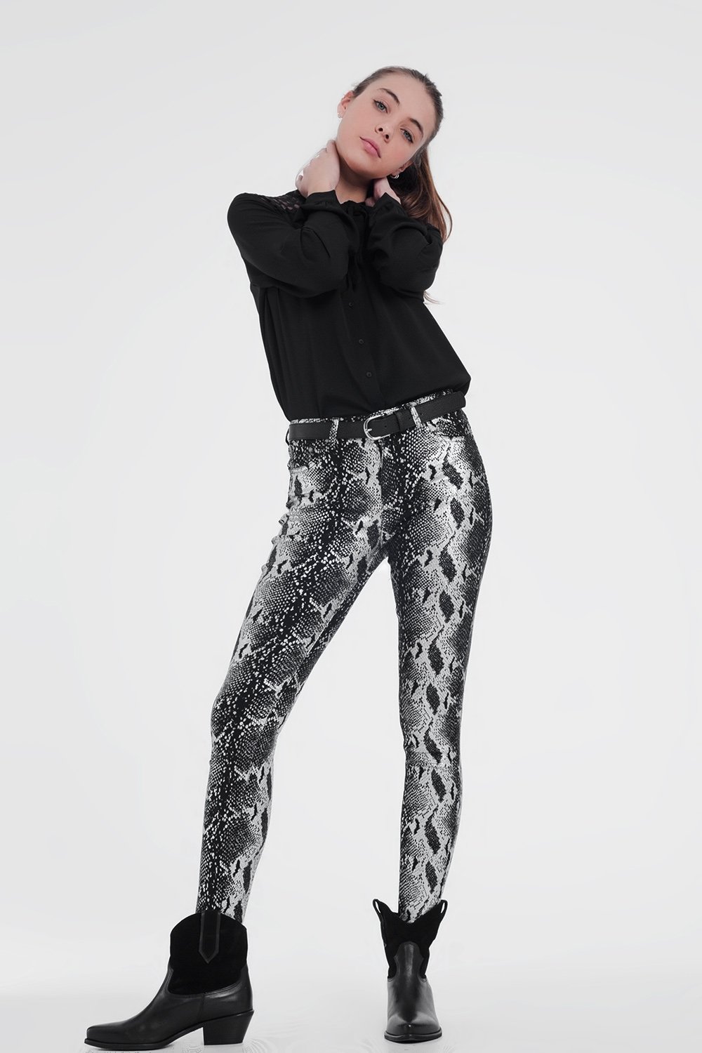 Black skinny shiny printed pants with zipper closure and pockets, showcasing a sleek and stylish design.