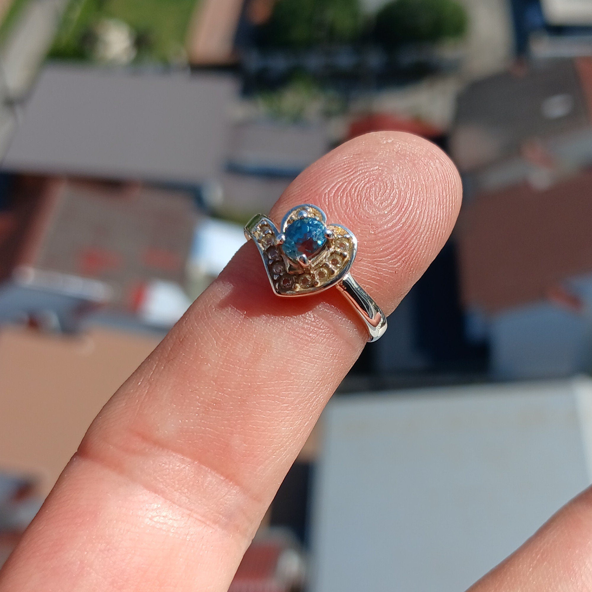 A polished sterling silver heart ring featuring an oval cut blue zircon gemstone, elegantly designed for cocktail occasions.