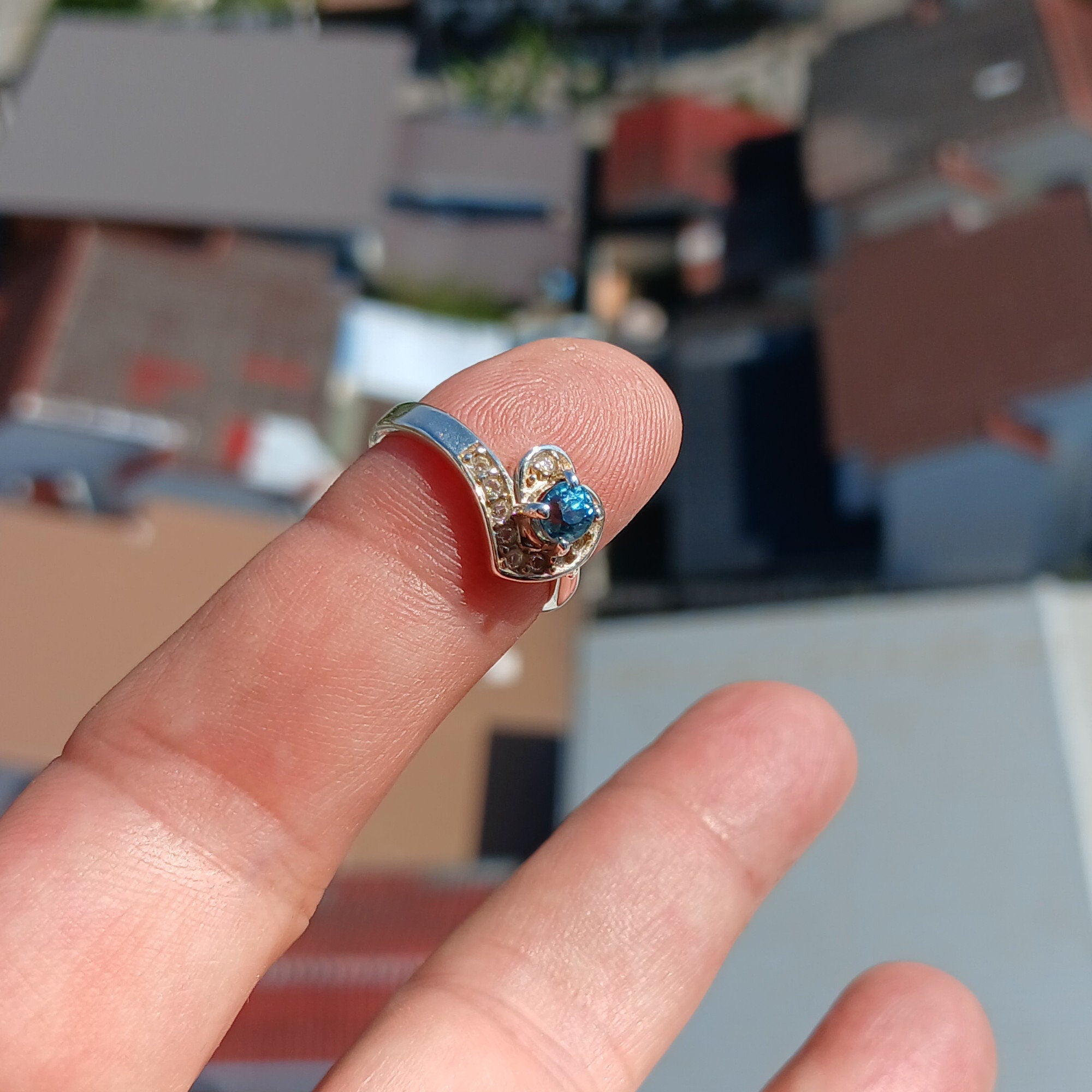 A polished sterling silver heart ring featuring an oval cut blue zircon gemstone, elegantly designed for cocktail occasions.