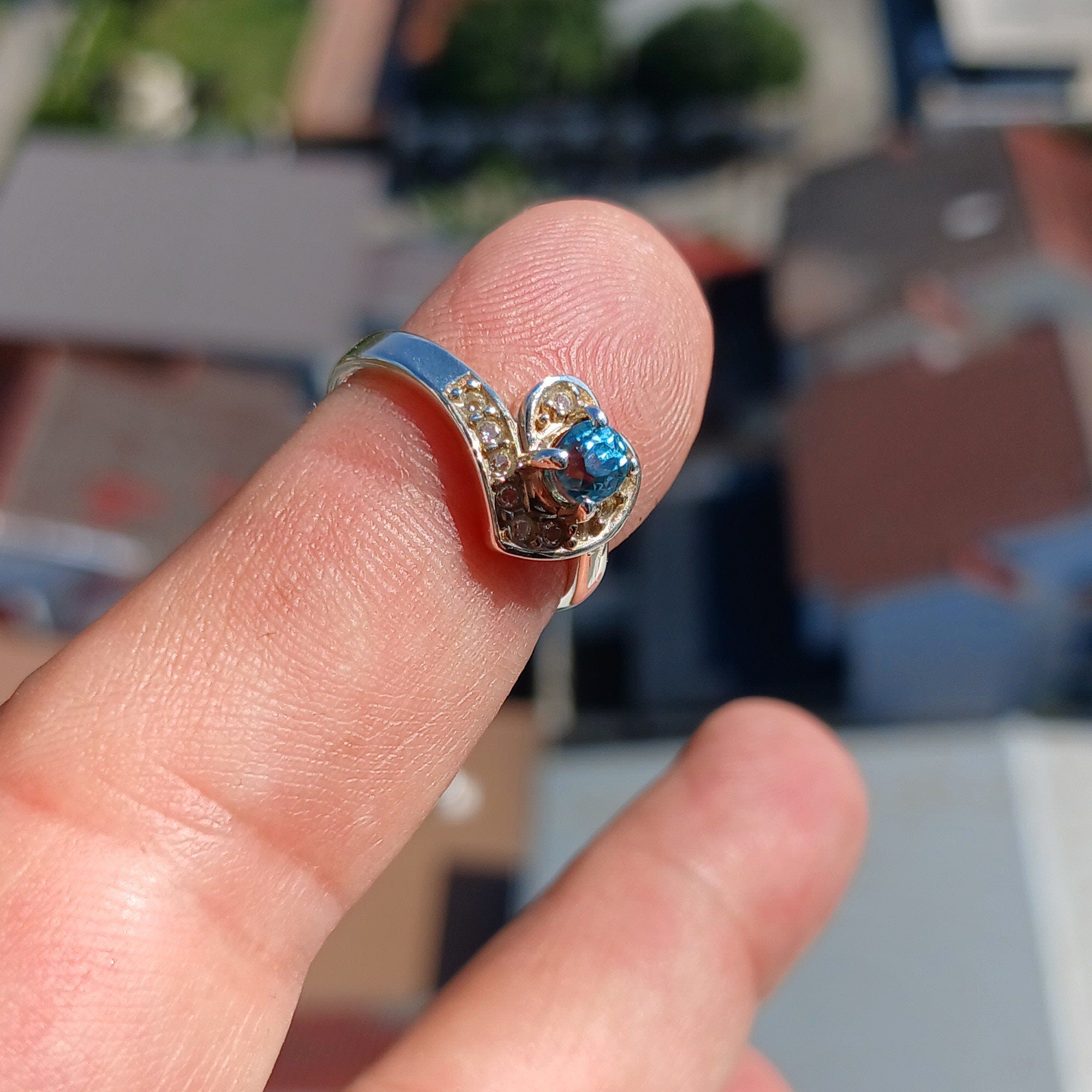 A polished sterling silver heart ring featuring an oval cut blue zircon gemstone, elegantly designed for cocktail occasions.