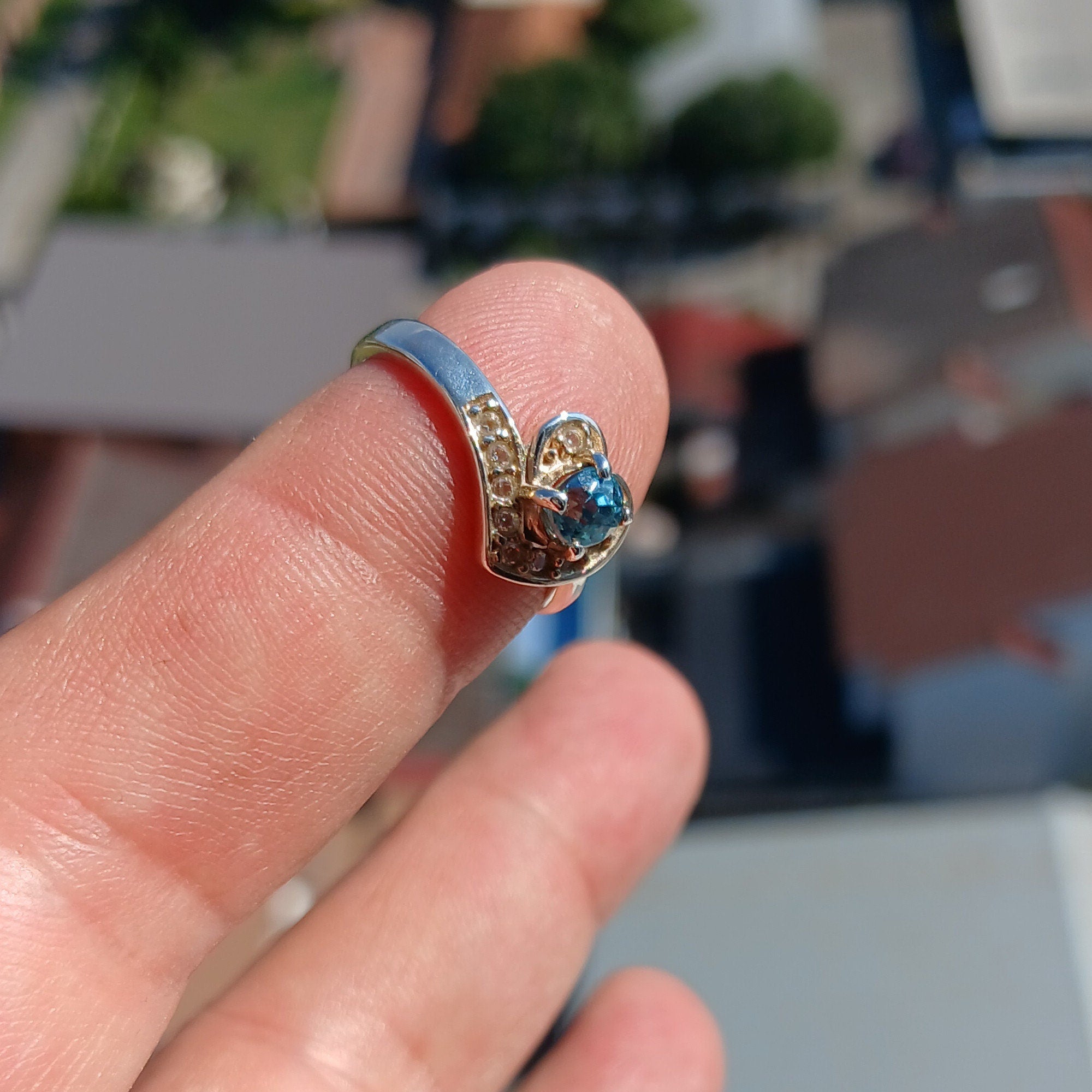 A polished sterling silver heart ring featuring an oval cut blue zircon gemstone, elegantly designed for cocktail occasions.