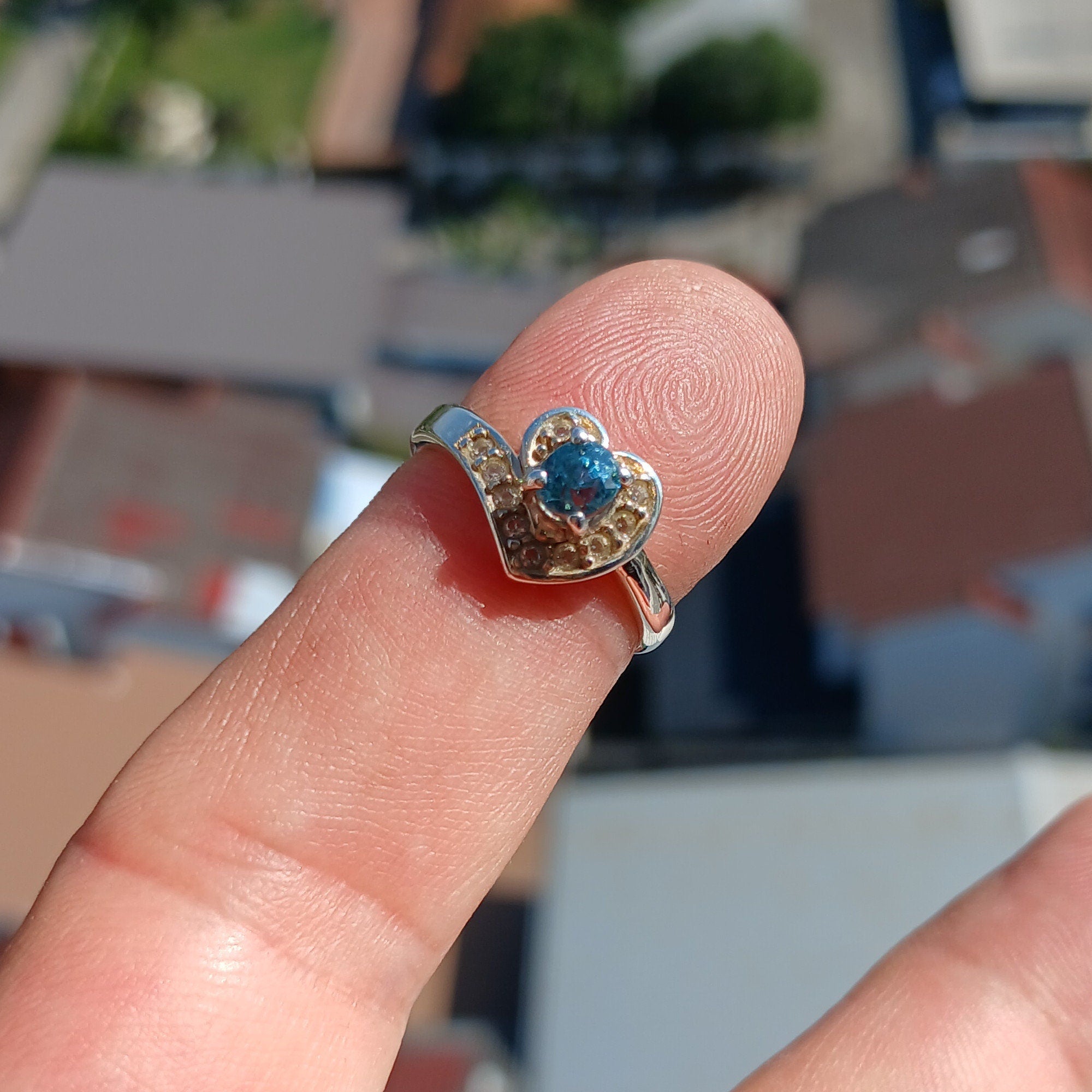 A polished sterling silver heart ring featuring an oval cut blue zircon gemstone, elegantly designed for cocktail occasions.