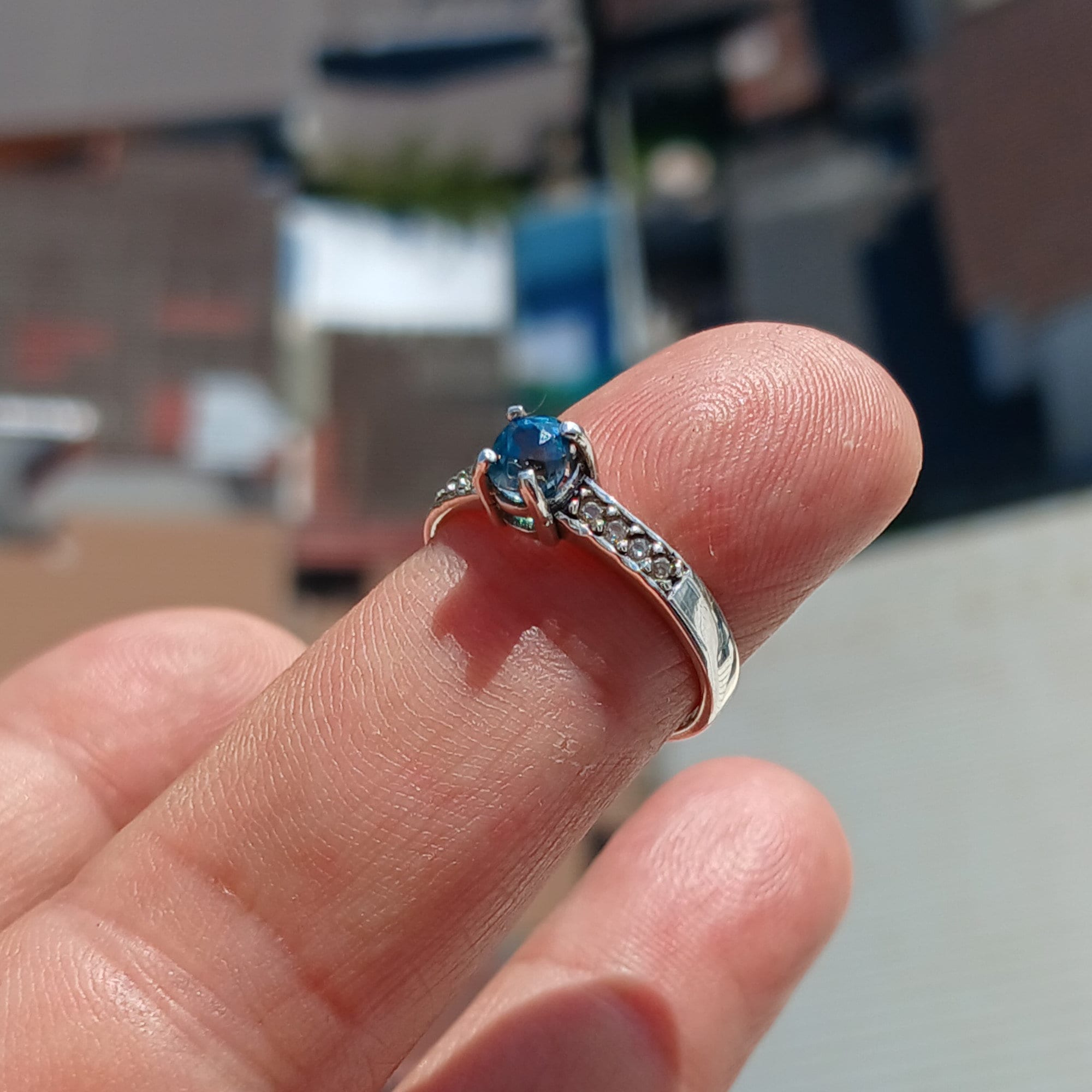 A stunning Blue Zircon Ring featuring an oval cut gemstone set in polished 925 Sterling Silver with sparkling CZ accents.