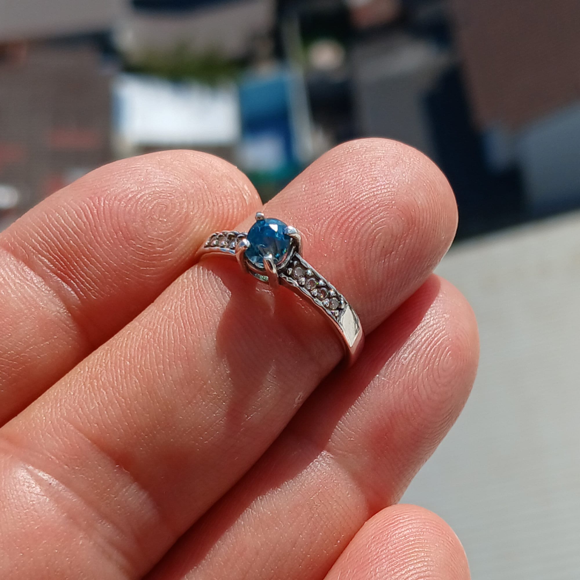 A stunning Blue Zircon Ring featuring an oval cut gemstone set in polished 925 Sterling Silver with sparkling CZ accents.