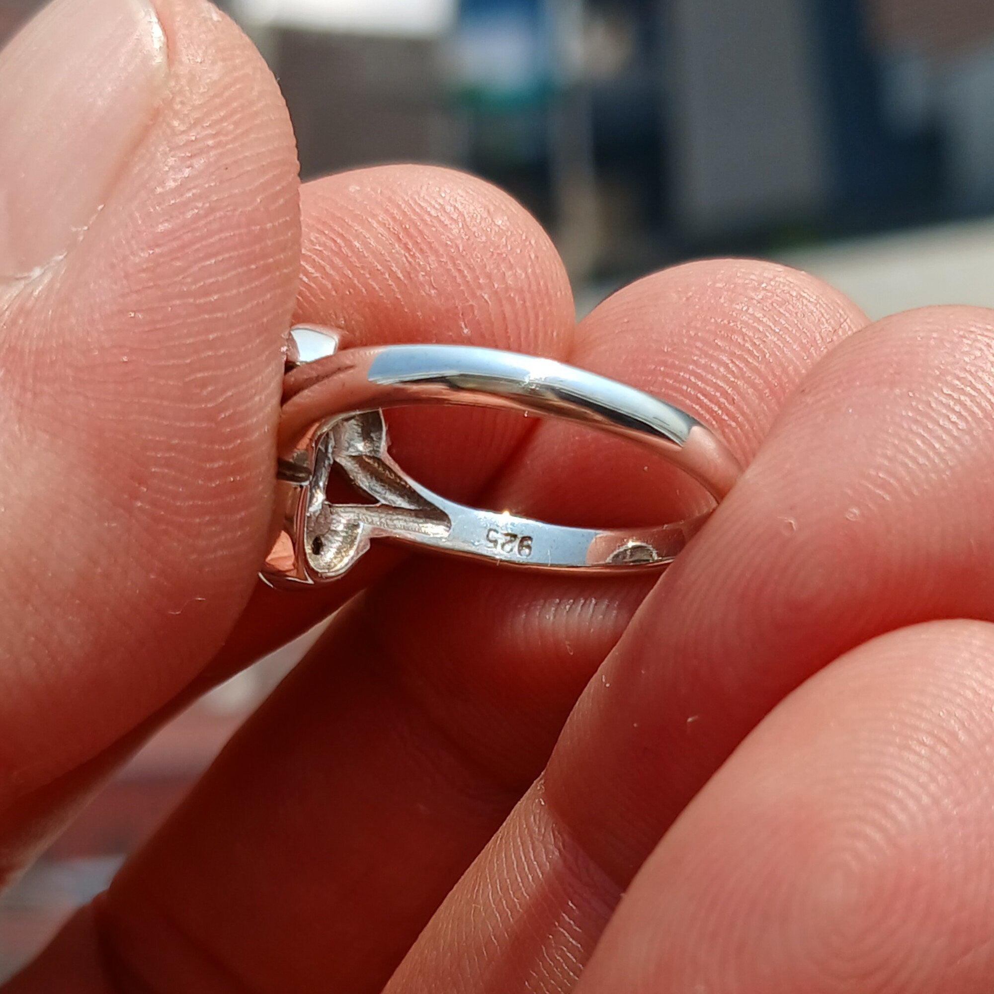 Handmade sterling silver ring featuring a blue zircon gemstone surrounded by eight cubic zirconia stones, elegantly polished.