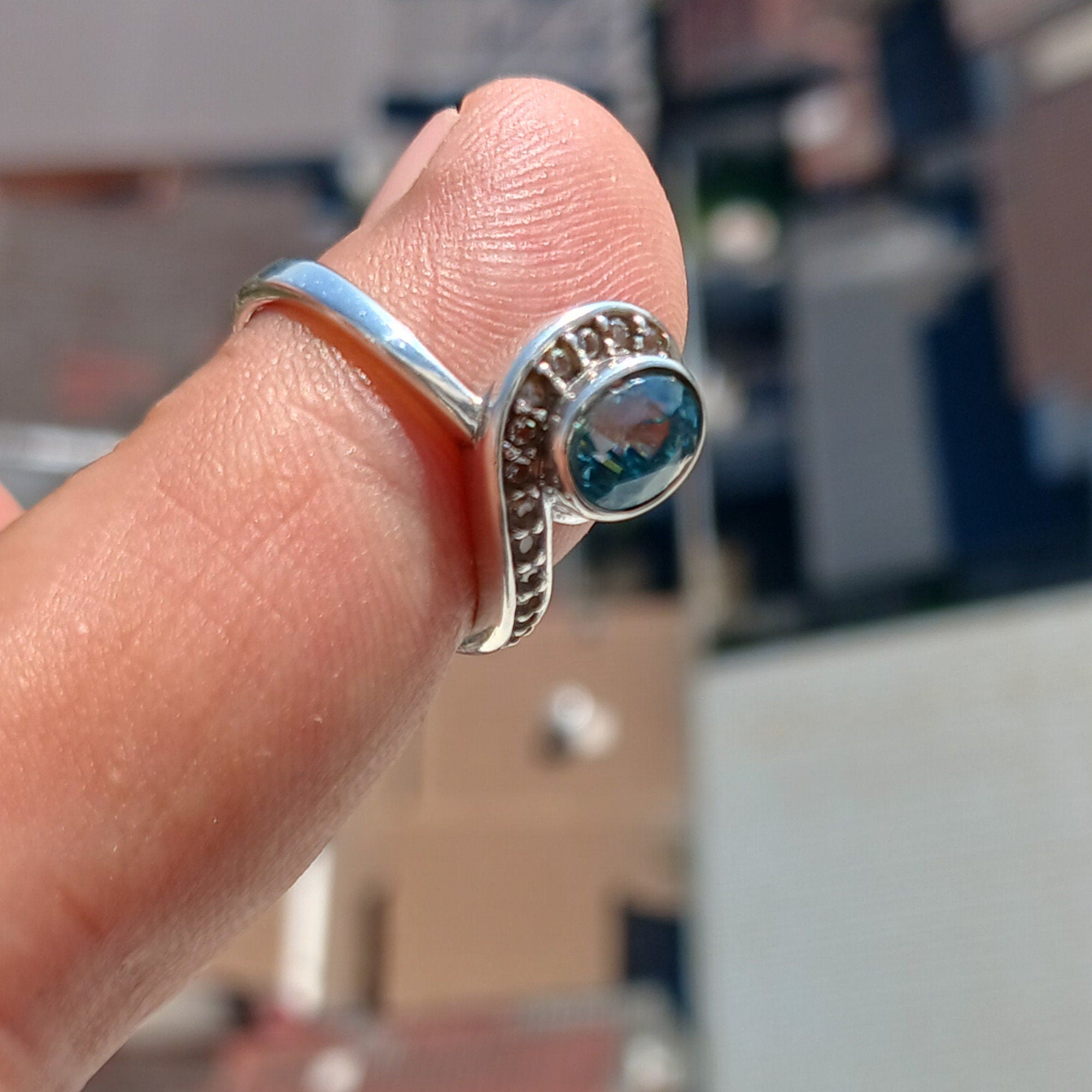 Handmade Blue Zircon Ring in sterling silver featuring an oval cut stone and 13 white CZ accents, perfect for elegant occasions.