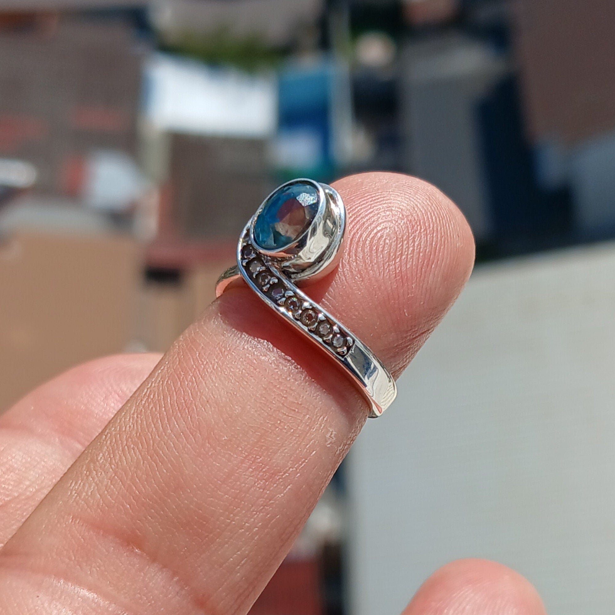 Handmade Blue Zircon Ring in sterling silver featuring an oval cut stone and 13 white CZ accents, perfect for elegant occasions.