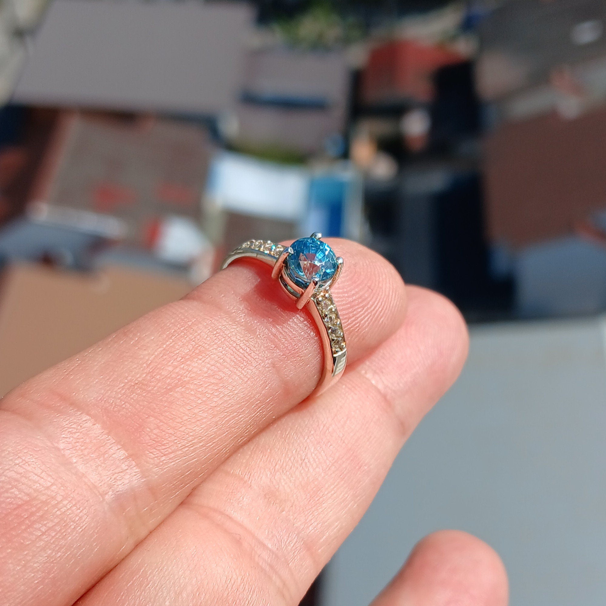 A stunning blue zircon ring set in polished sterling silver, showcasing a round cut gemstone with a hallmarked 925 band.