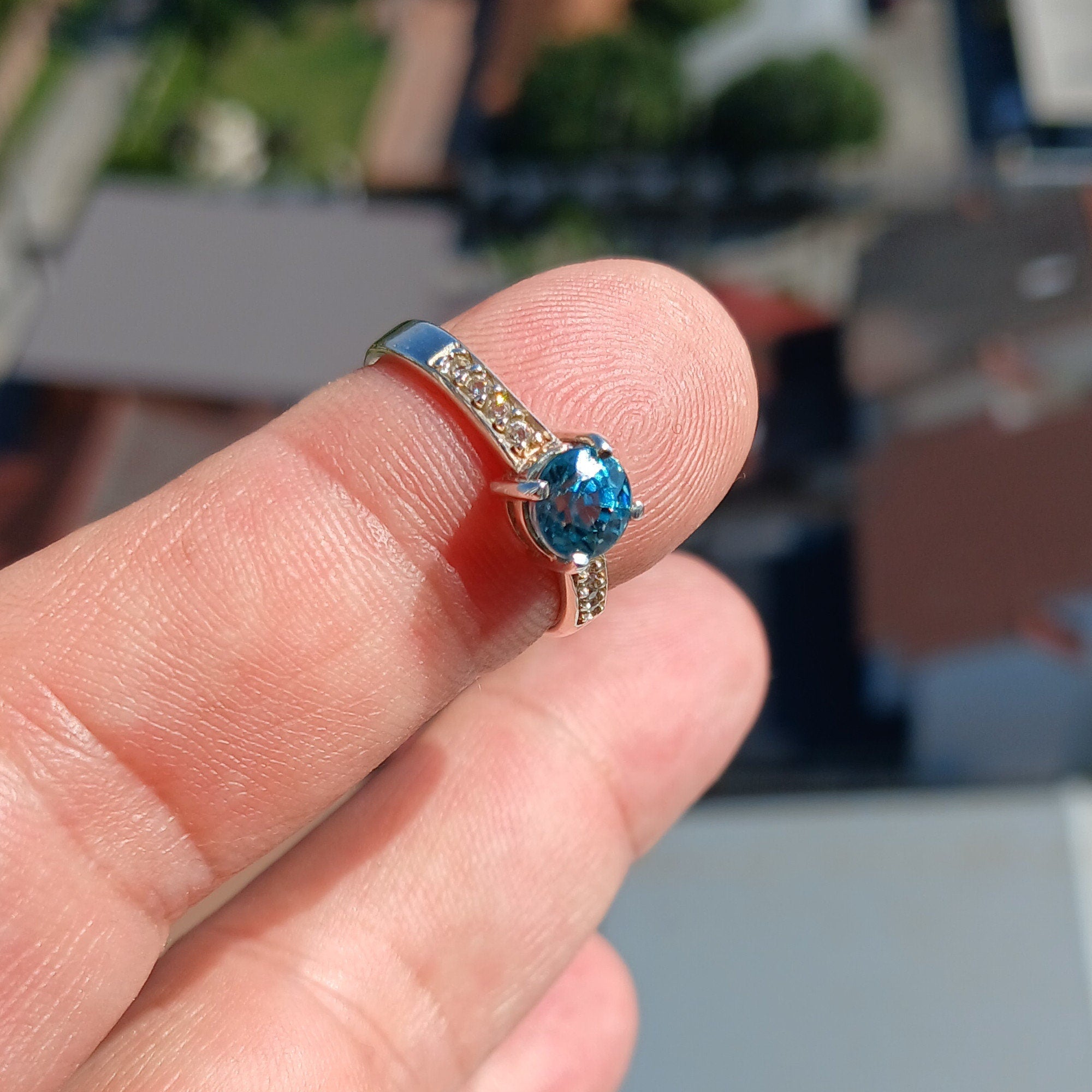 A stunning blue zircon ring set in polished sterling silver, showcasing a round cut gemstone with a hallmarked 925 band.