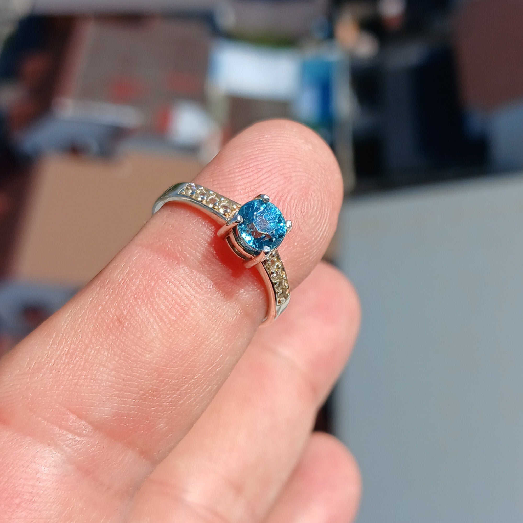 A stunning blue zircon ring set in polished sterling silver, showcasing a round cut gemstone with a hallmarked 925 band.