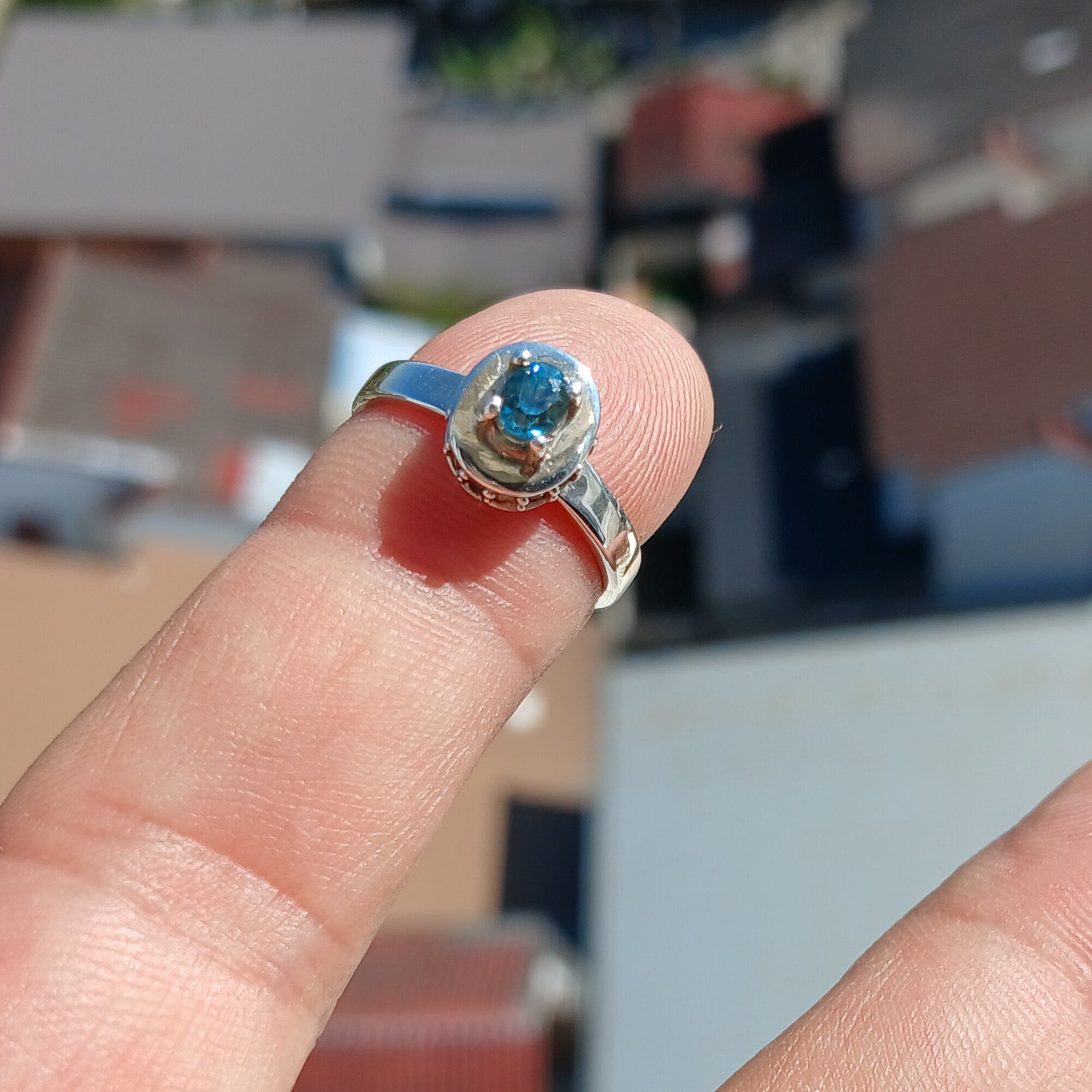 A stunning Blue Zircon Ring featuring a natural gemstone set in polished sterling silver, adorned with 14 white CZ stones.