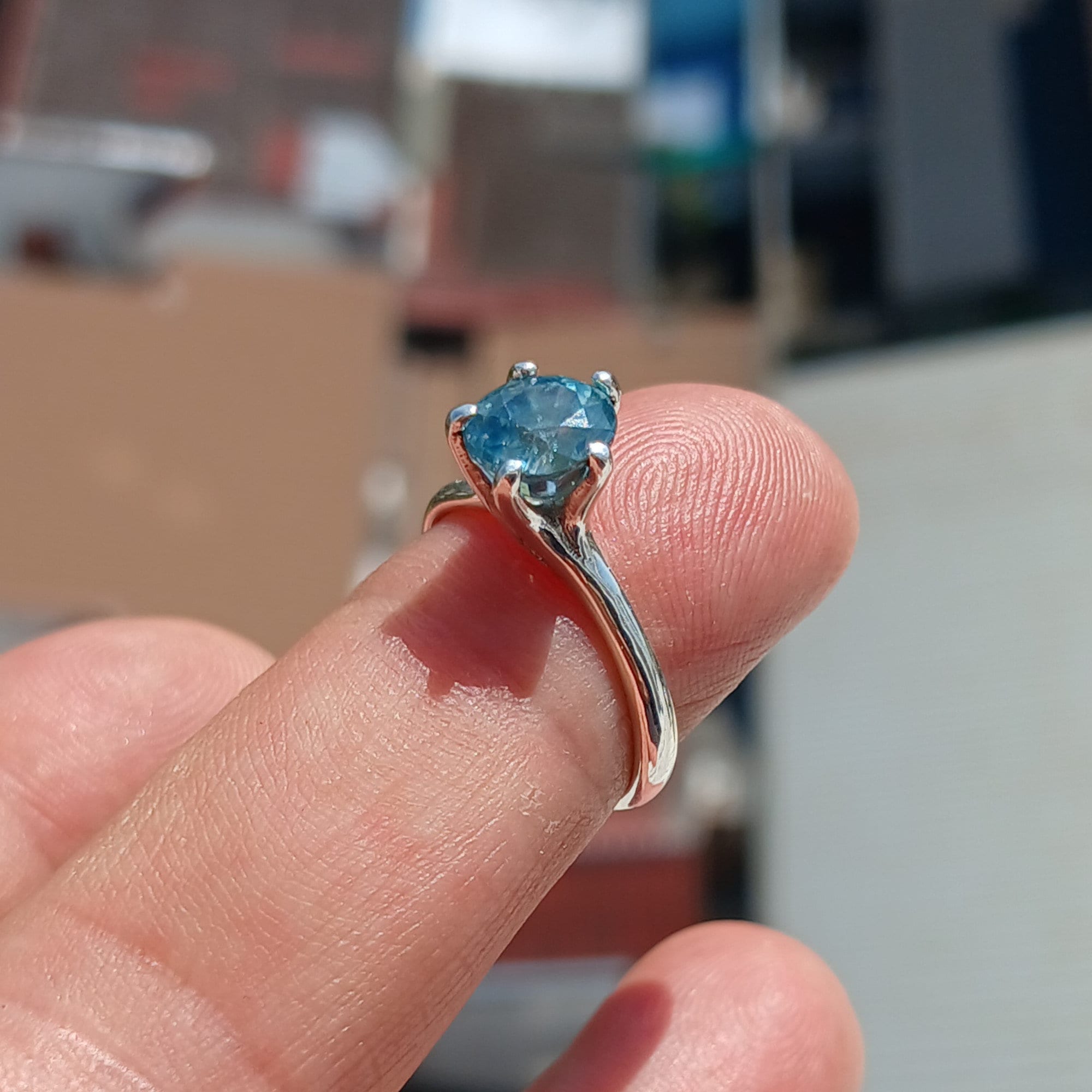 A stunning Blue Zircon Ring set in polished sterling silver, featuring an oval-cut blue gemstone in a solitaire design.