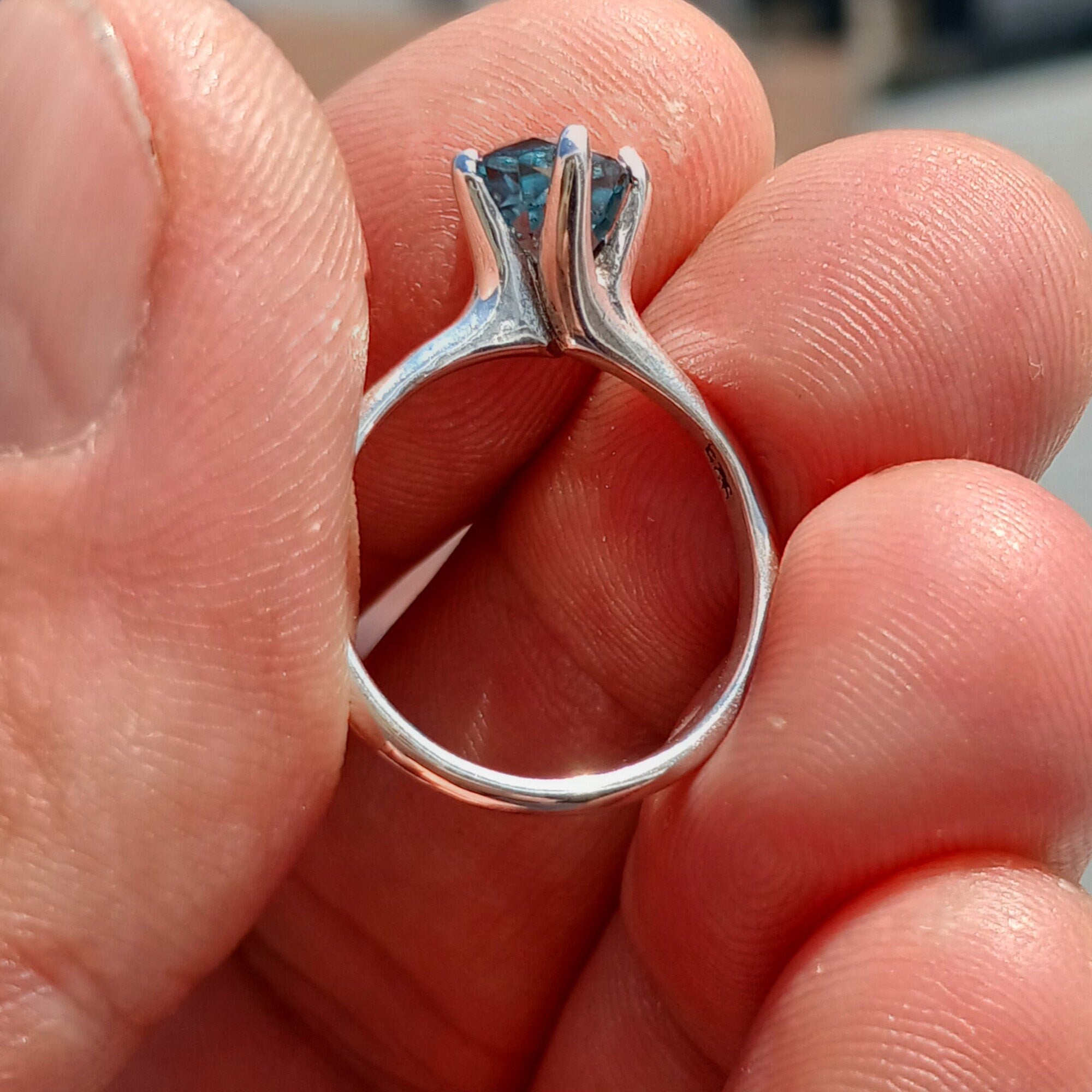 A stunning Blue Zircon Ring set in polished sterling silver, featuring an oval-cut blue gemstone in a solitaire design.