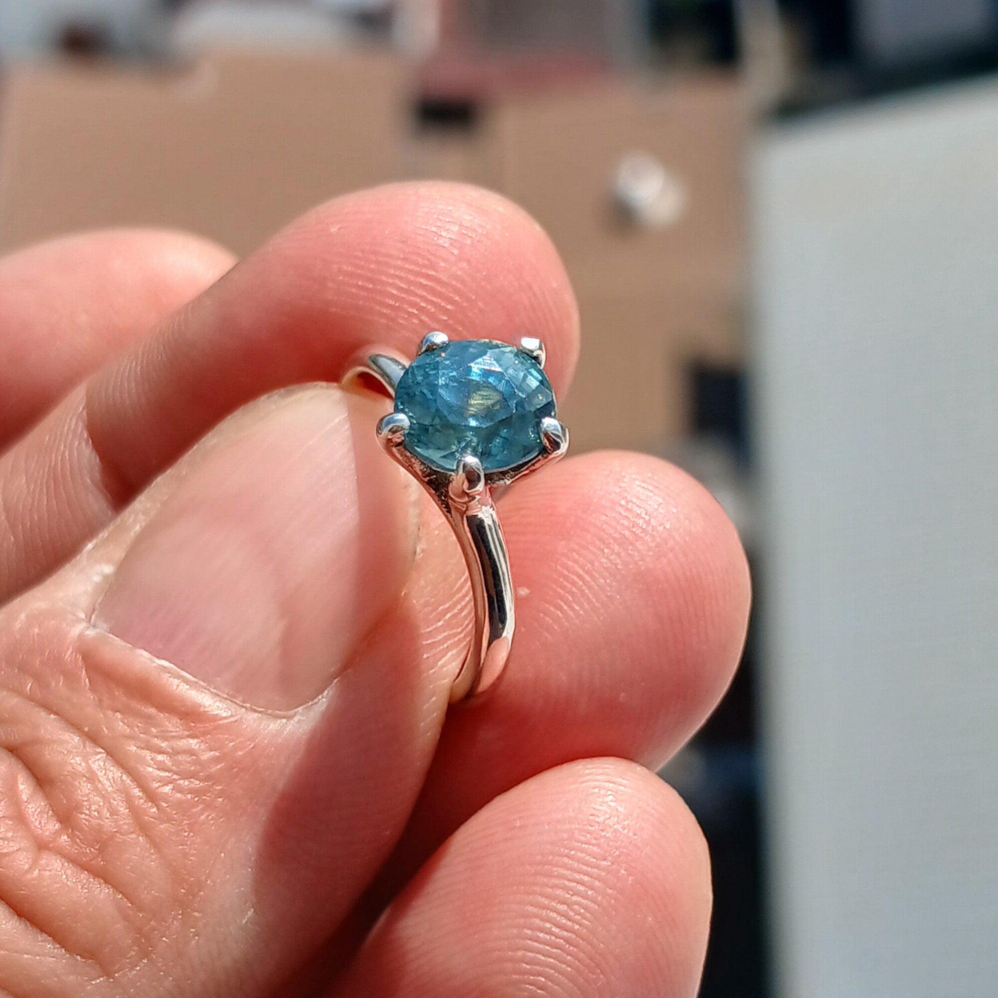 A stunning Blue Zircon Ring set in polished sterling silver, featuring an oval-cut blue gemstone in a solitaire design.