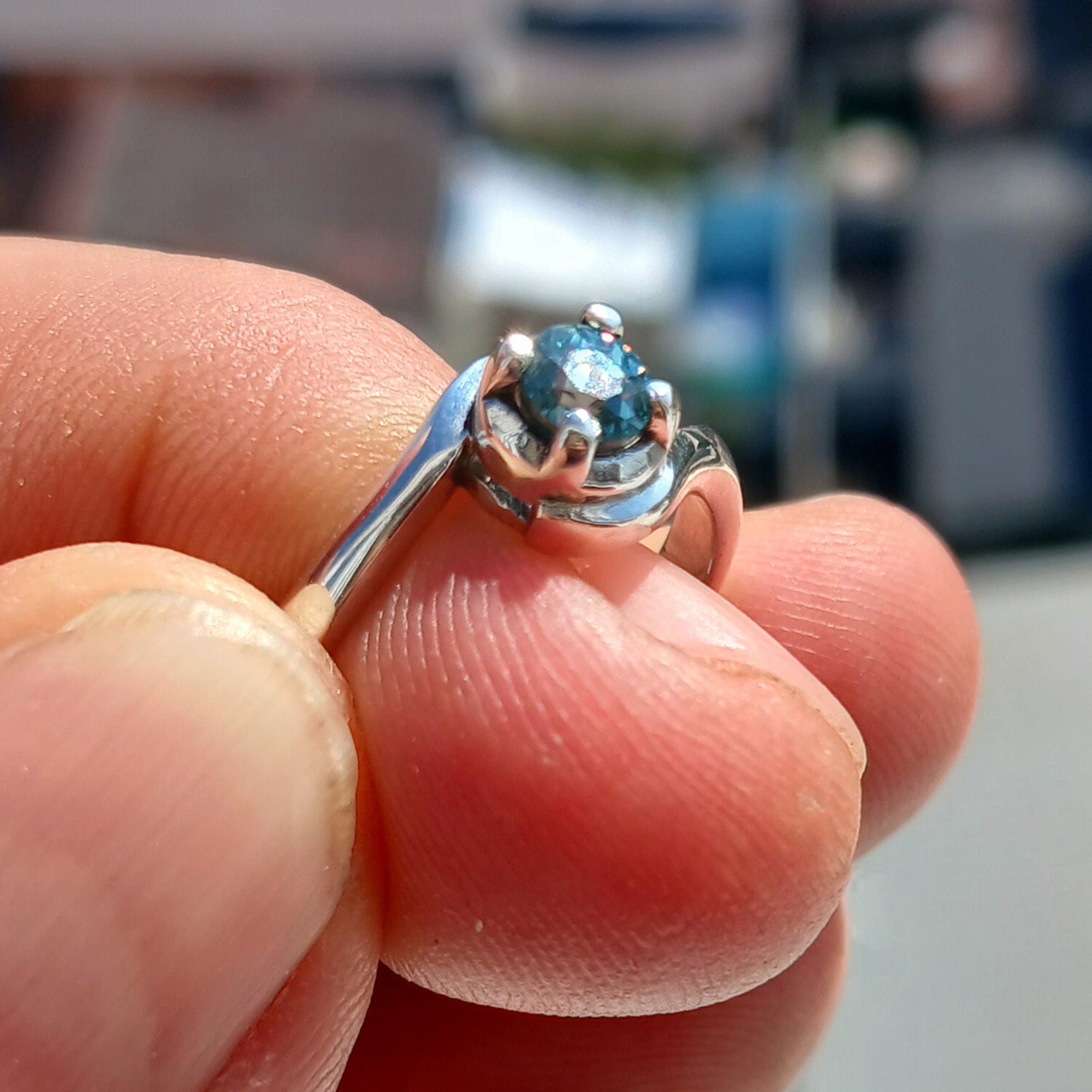 A stunning Blue Zircon Ring set in polished sterling silver, featuring a round cut blue gemstone in a solitaire design.